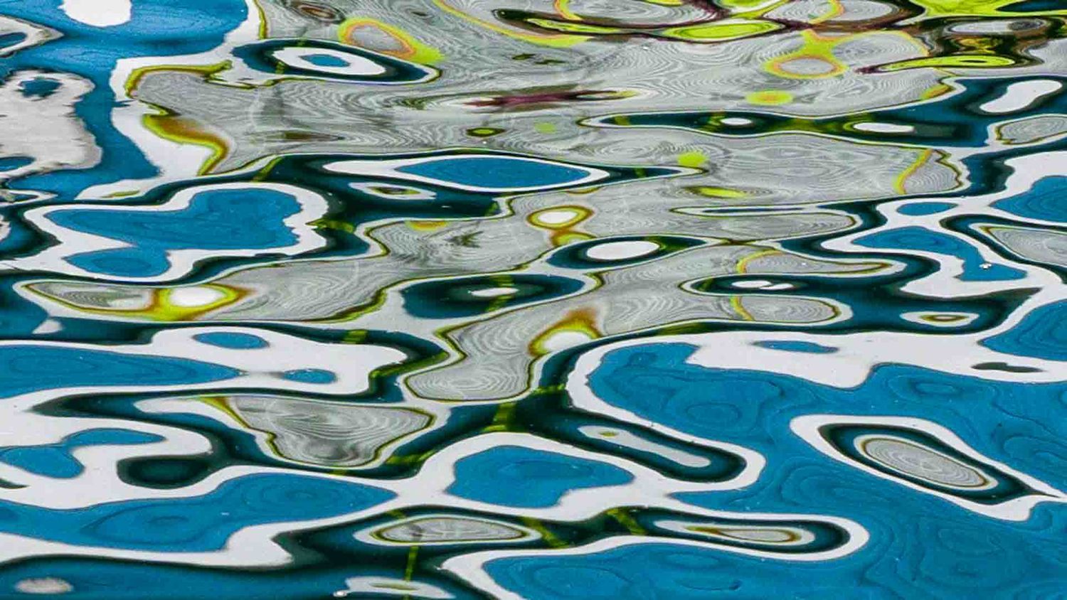 Abstract water reflection creating colorful patterns in blue and yellow tones.