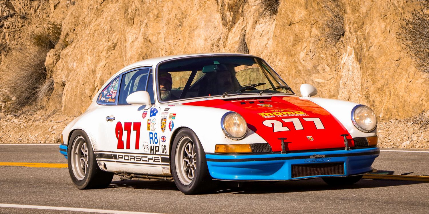 Classic Porsche 911 race car with number 177 racing on a mountain road.