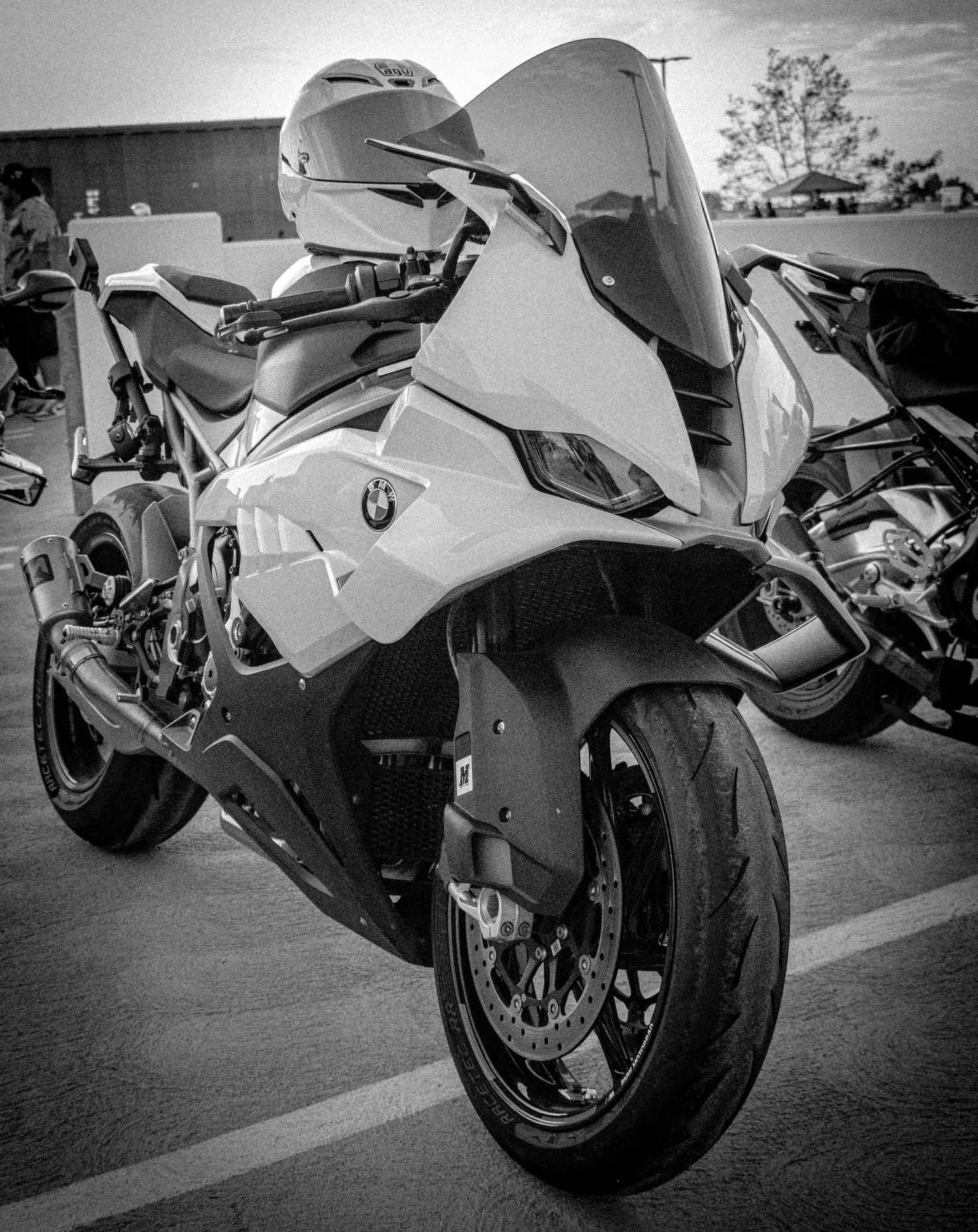 Black and white photo of a BMW S1000RR superbike parked in a lot, showcasing its aggressive aerodynamic fairing design.