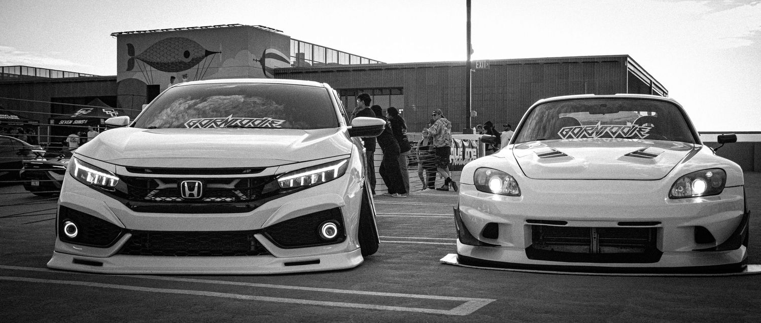 Two modified Honda cars, a Civic and an S2000, displayed at a car show in black and white photography.