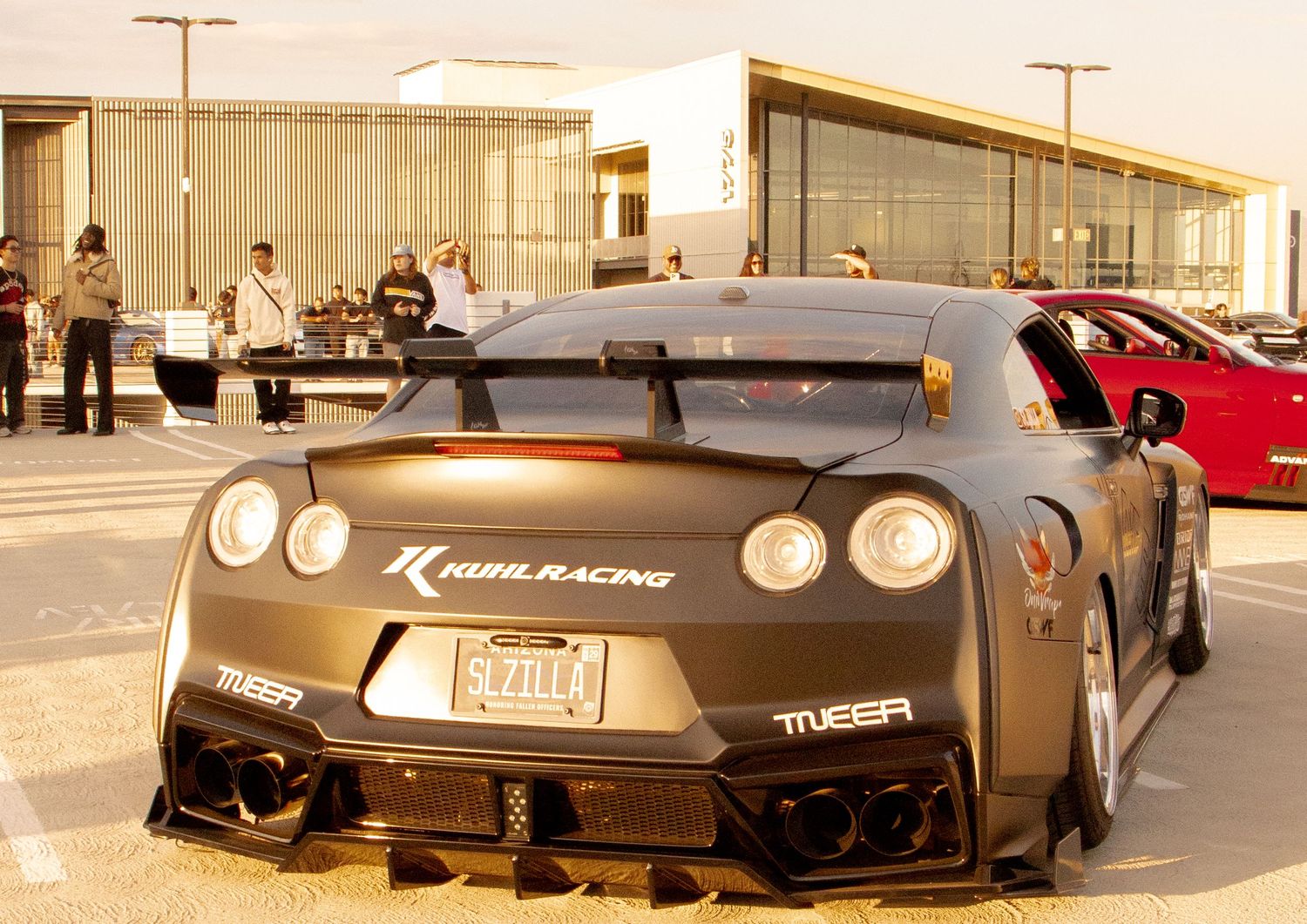 Kuhl Racing modified Nissan GT-R race car in matte black with aggressive wide body kit parked at a motorsport event.