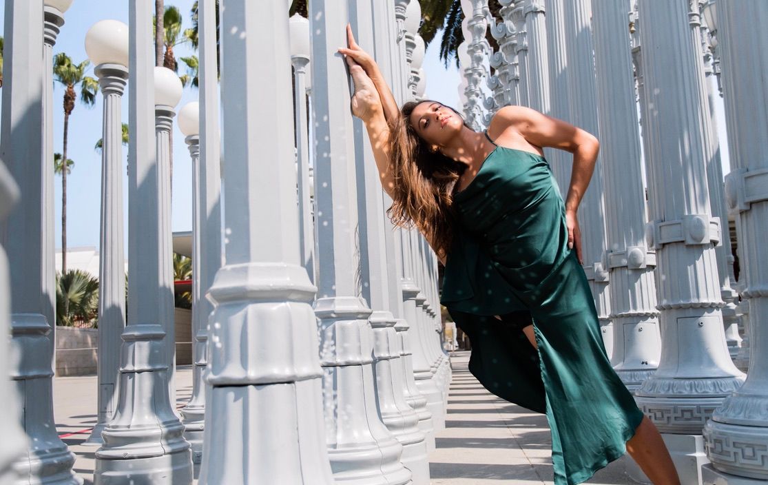 Graceful dance movements photographed among white urban light posts.