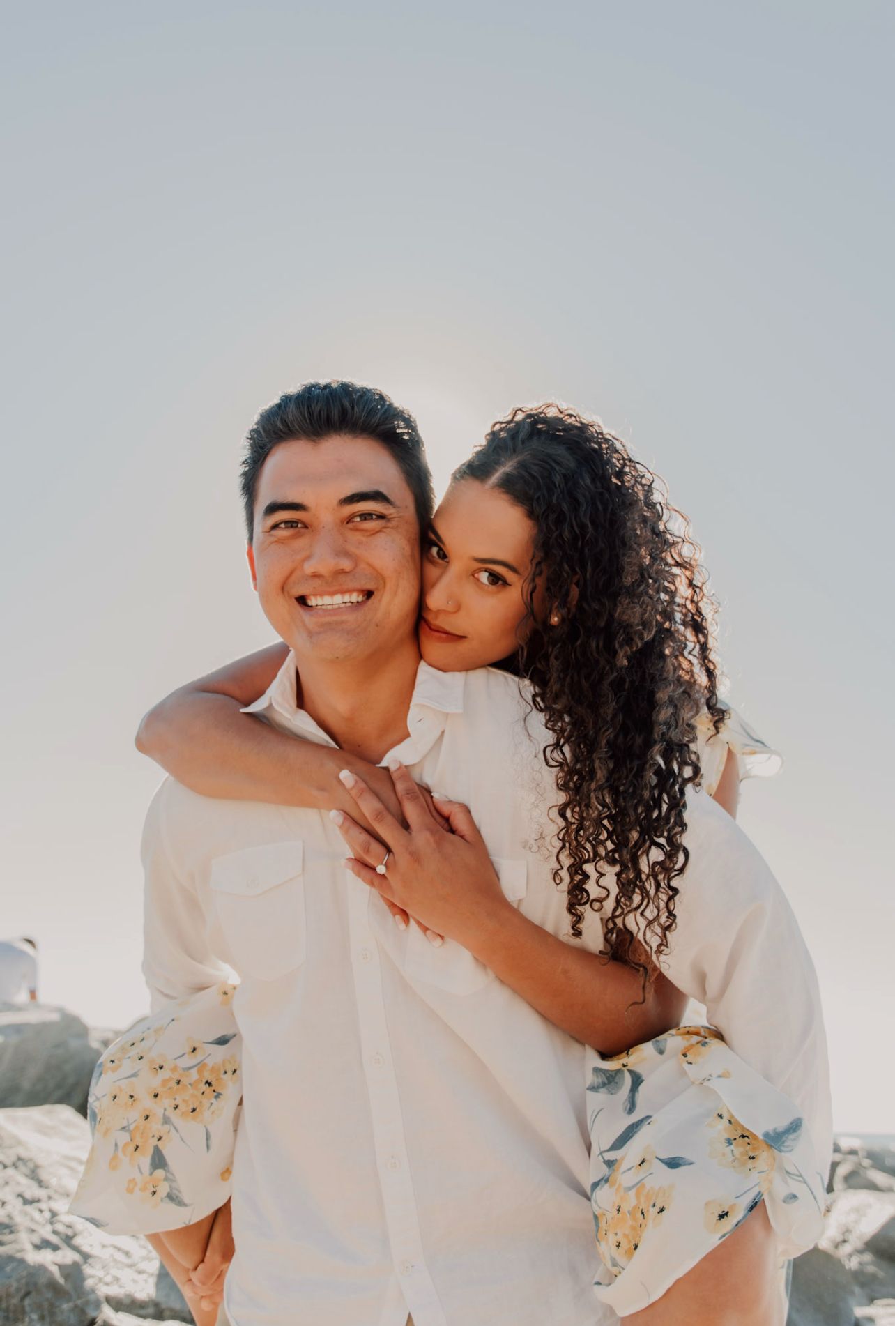 Joyful couple shares intimate moments during beach photoshoot.