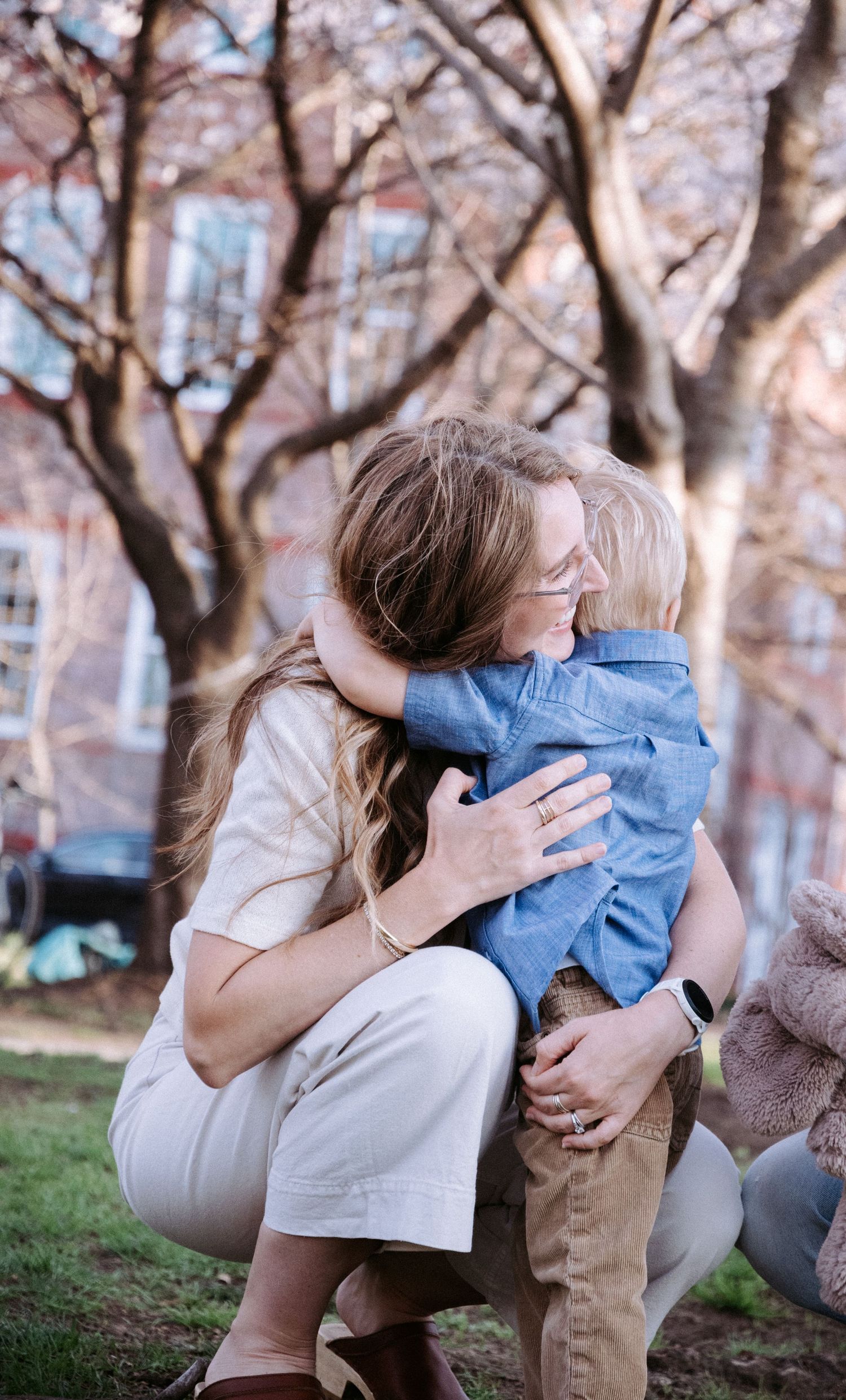A tender moment captured under blooming cherry blossom trees in springtime.