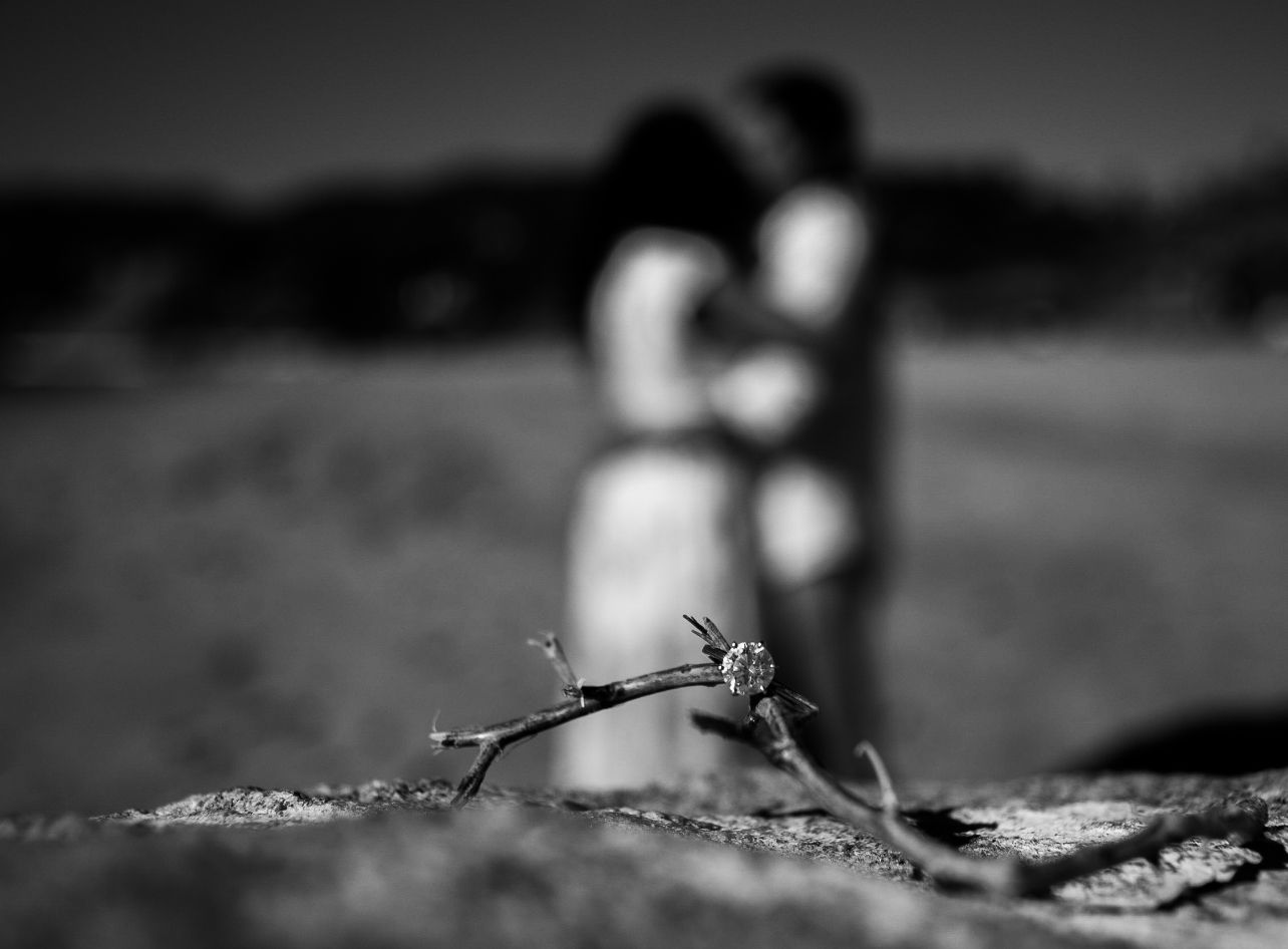 Artistic black and white beach photoshoot with blurred background.