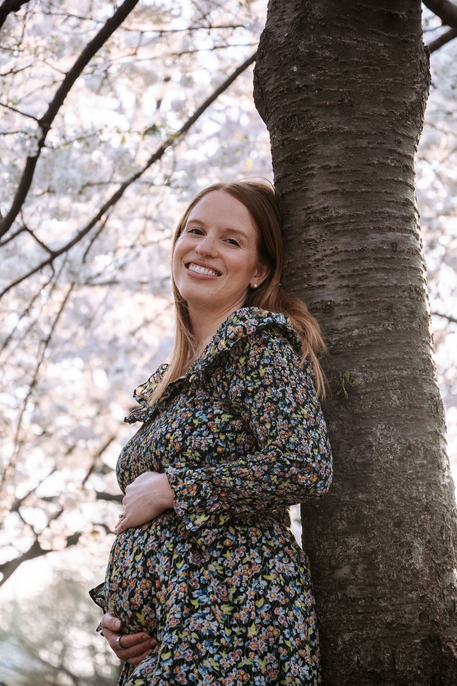 Spring portrait session under cherry blossoms with natural lighting and soft expressions.