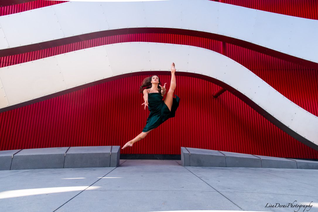 Dynamic dance sequence showing splits and leaps against architectural backdrop.