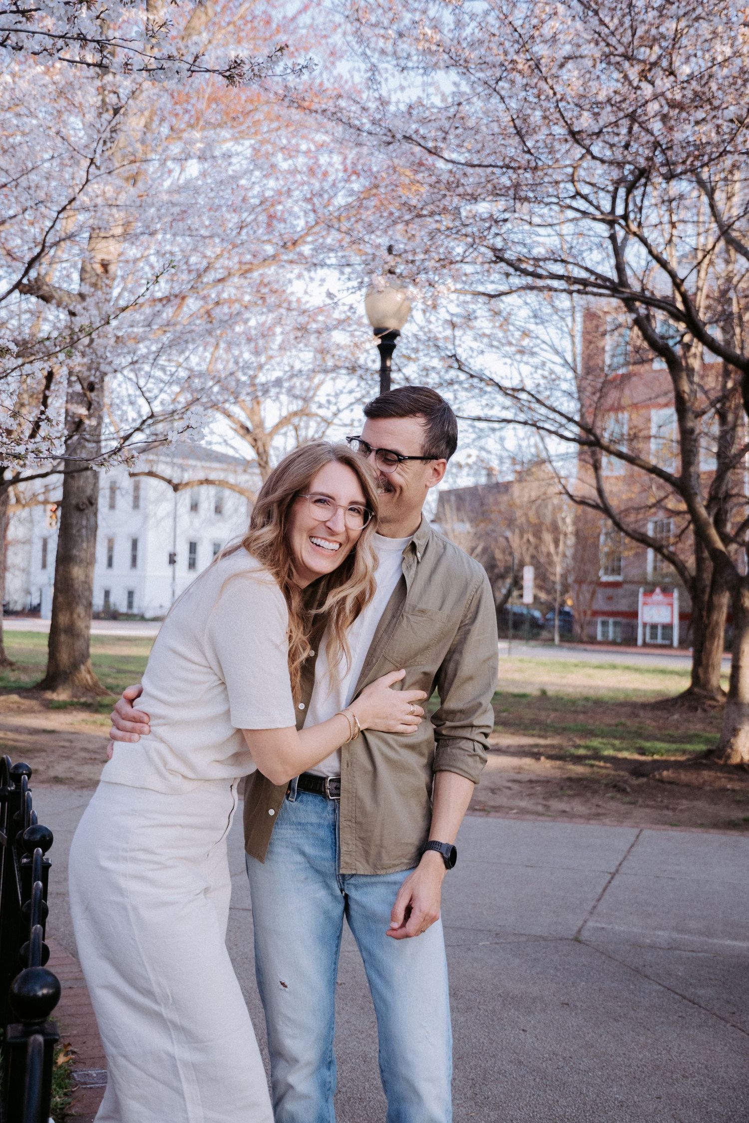 Casual outdoor portraits taken under blooming cherry blossom trees.