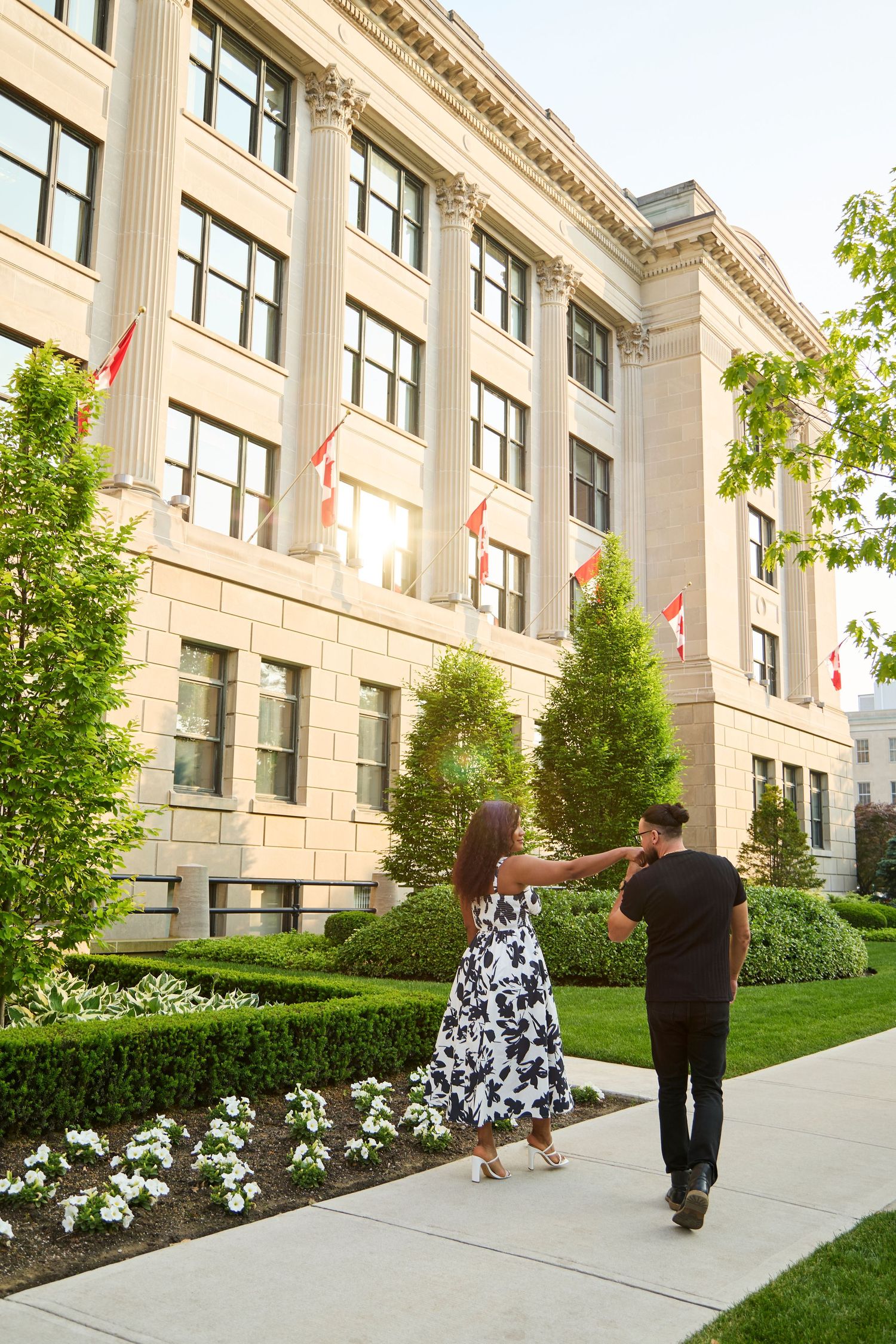 Engaged couple walking by Canada Life Building in London, ON.