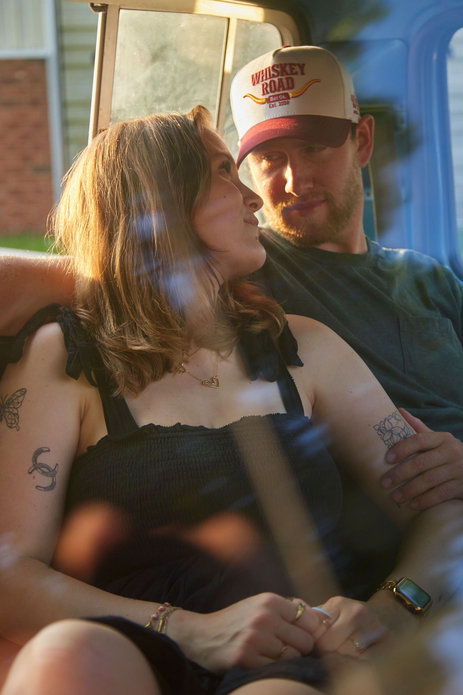 Couple admired each other in vintage truck through glass.