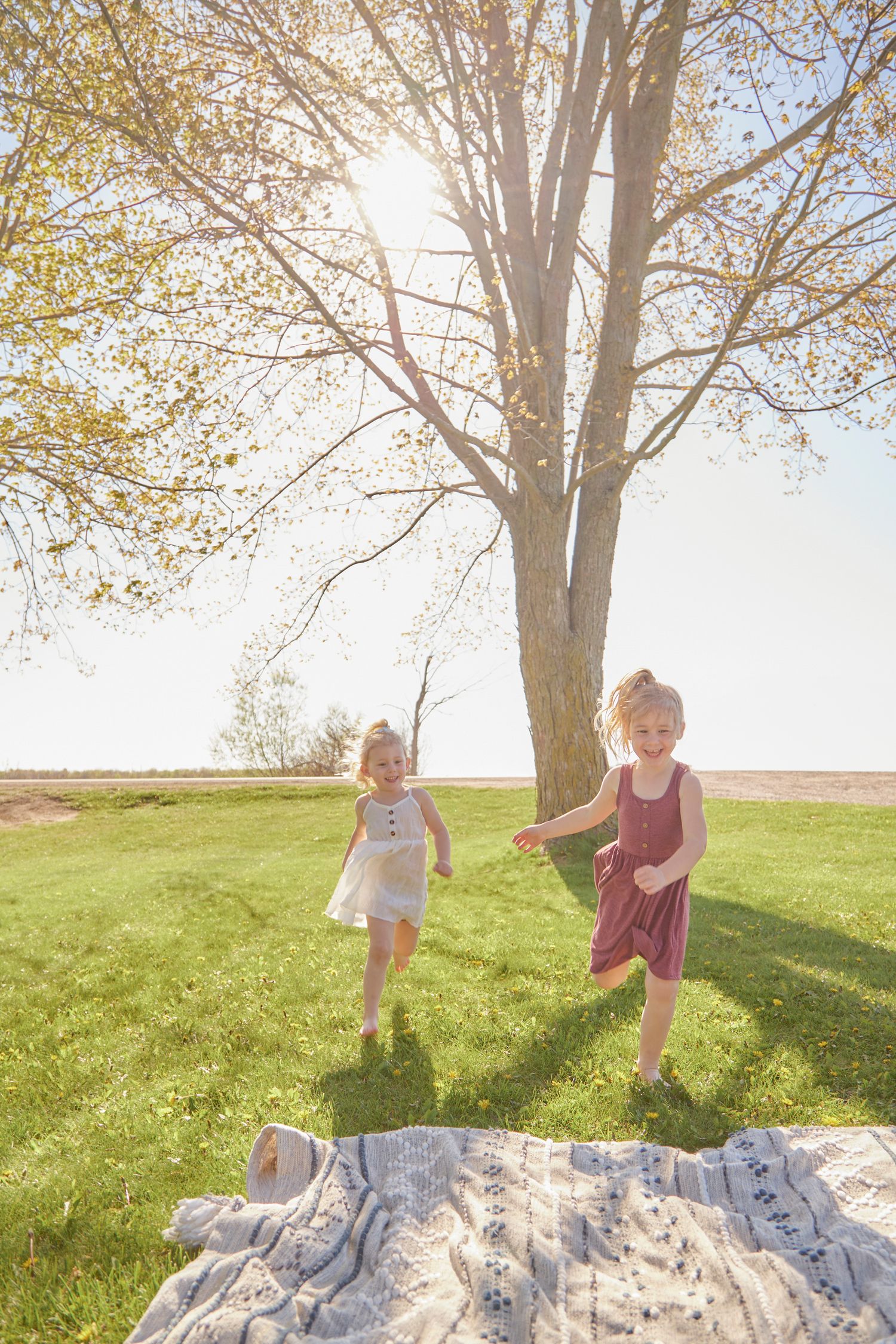 Sisters play in field in spring setting.
