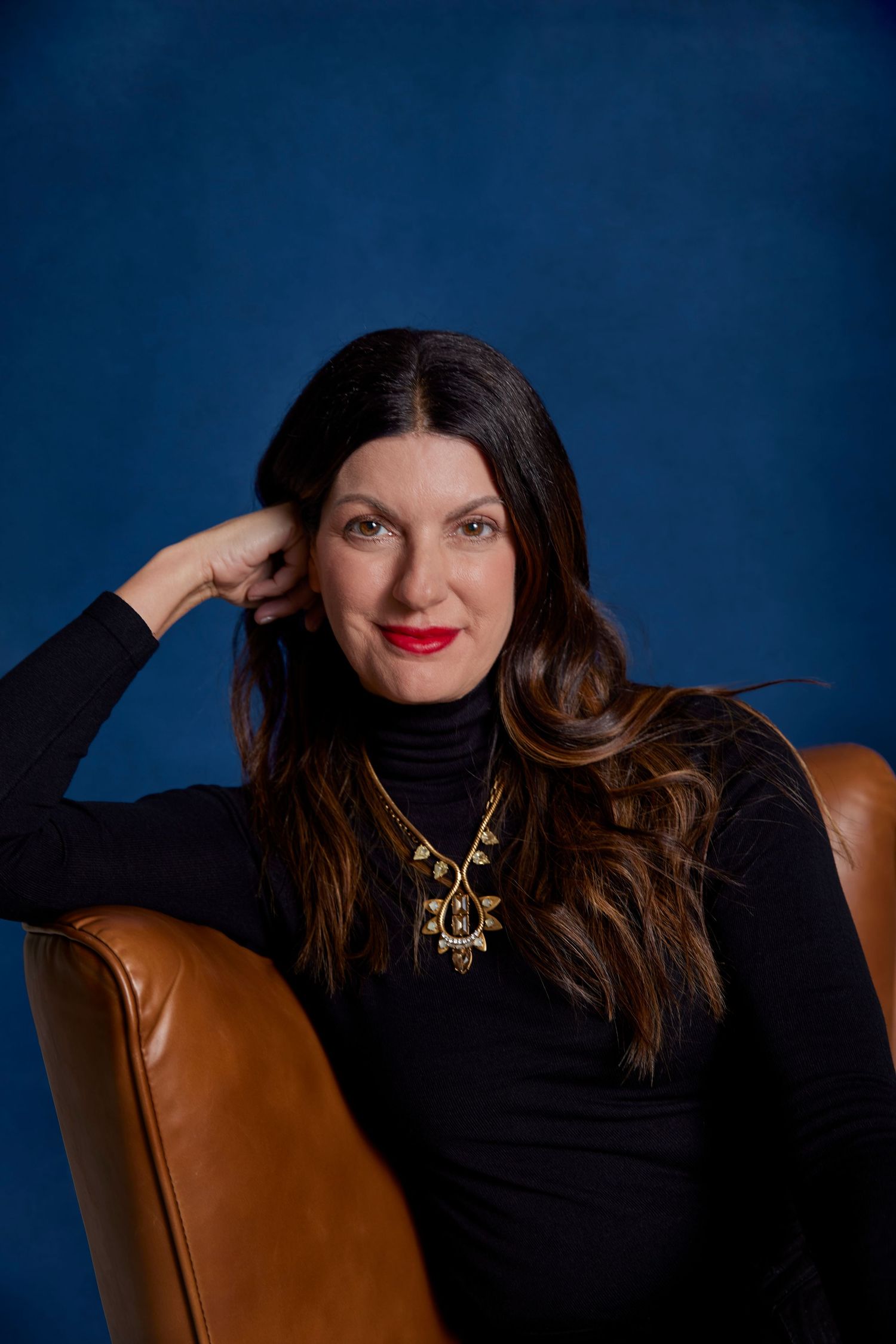 Headshot of woman on blue background.