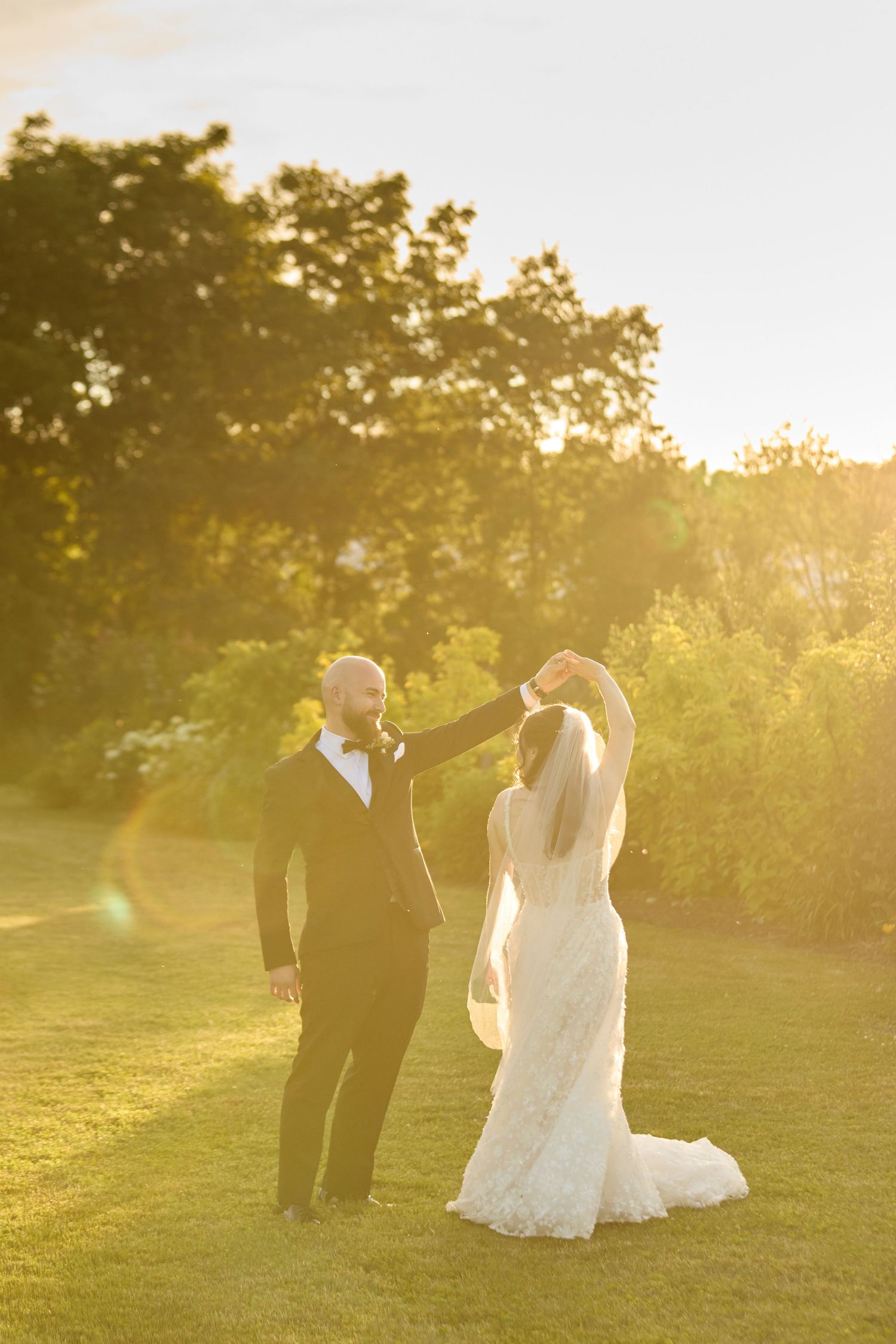 Bride and groom at golden hour sunset in floral field.