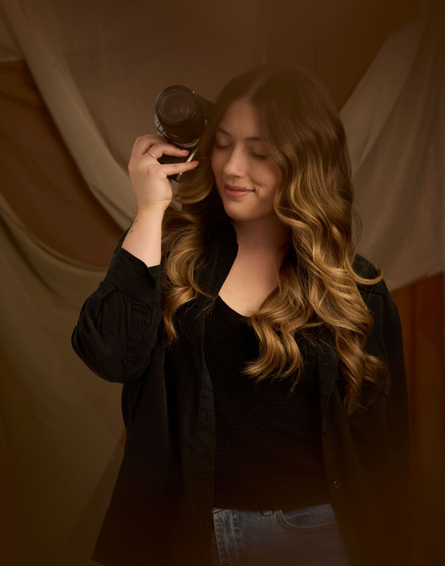 Headshot of Charlotte Poolton on brown fabric background.