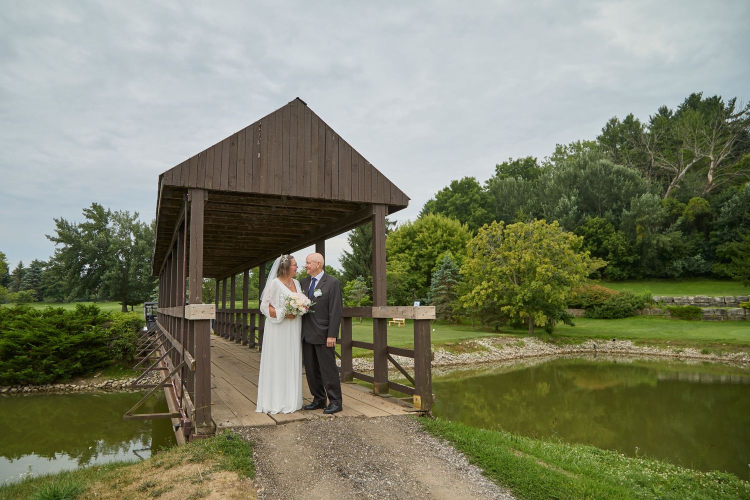 Bride and groom in covered bridge.