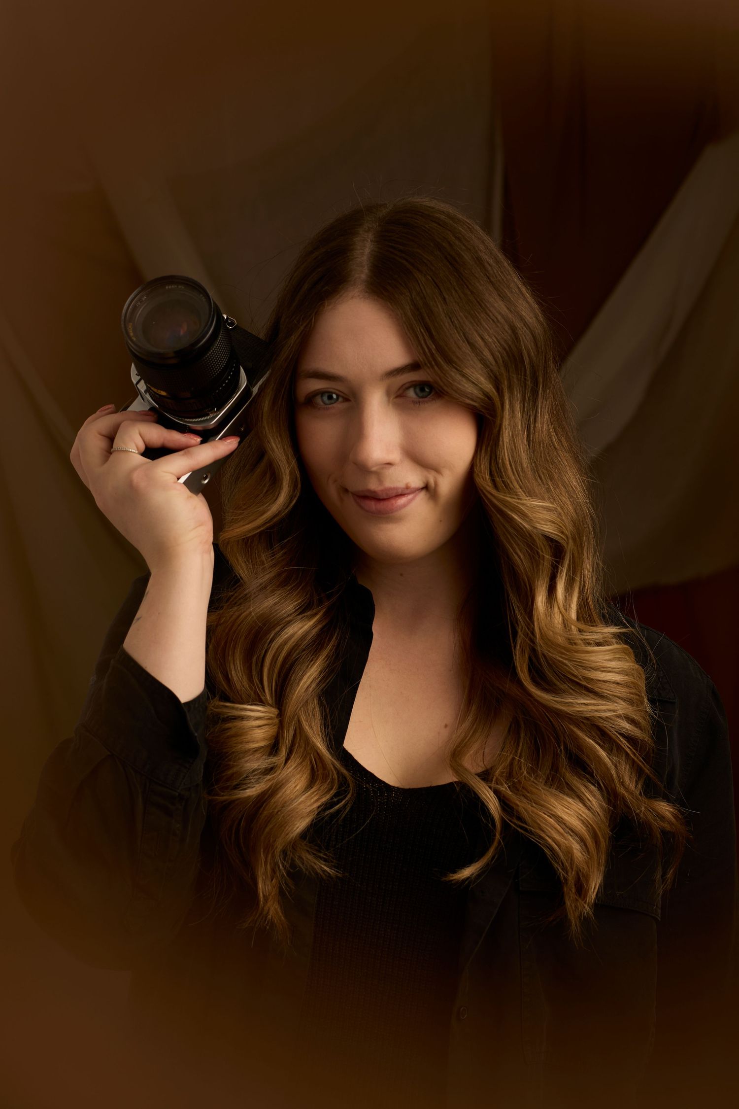 Headshot of Charlotte Poolton on brown fabric background.