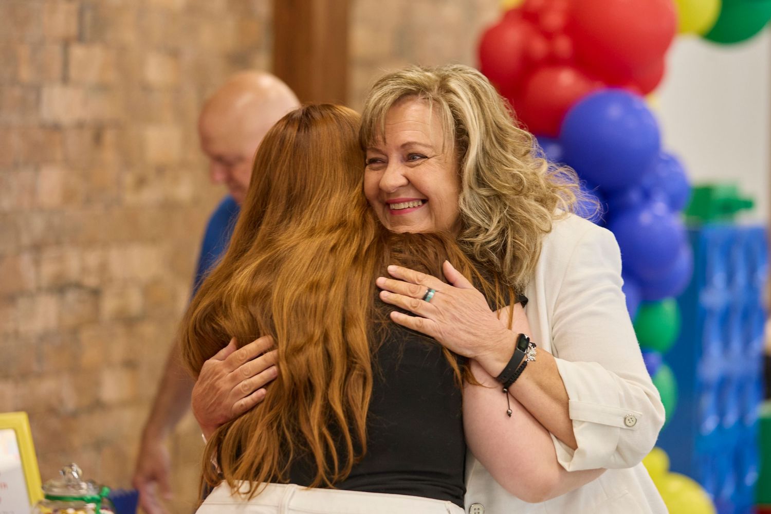 Friends hugging at event.