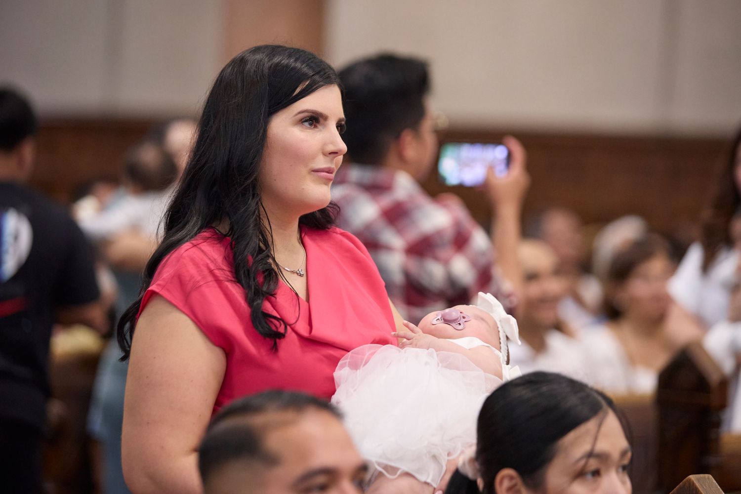 Mother holding baby at baptism.
