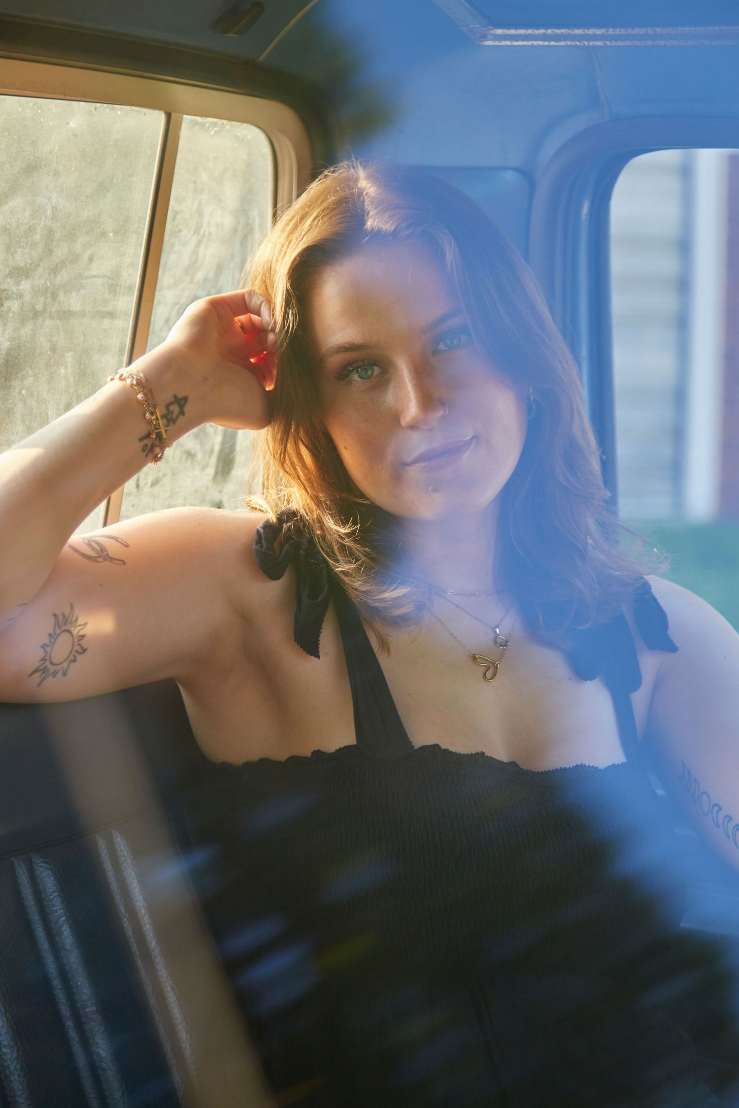 Woman in vintage truck through glass reflection.