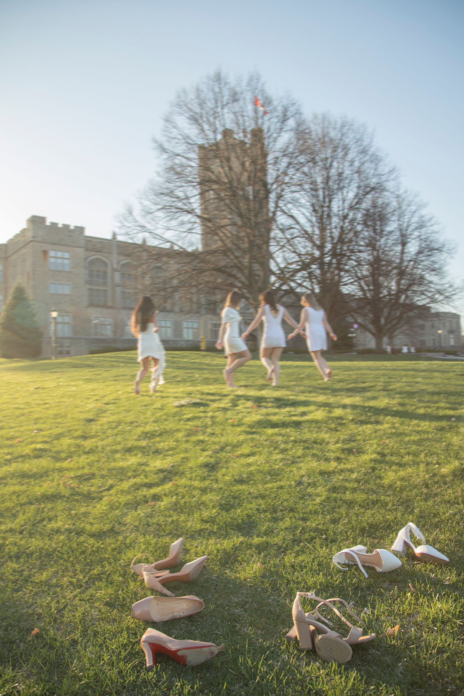 Grad session of 4 girls running in field at Western University.