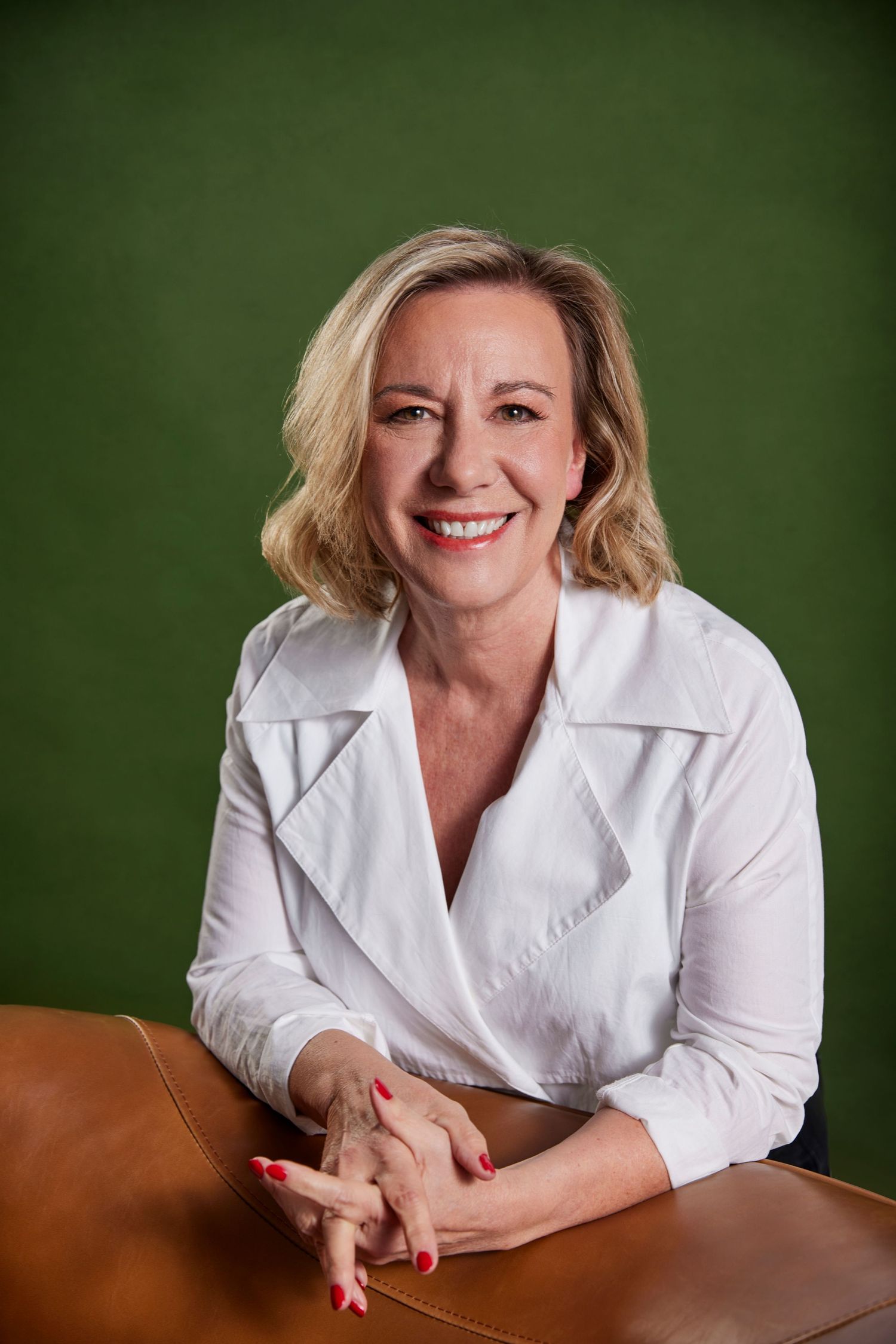 Headshot of woman on green background.