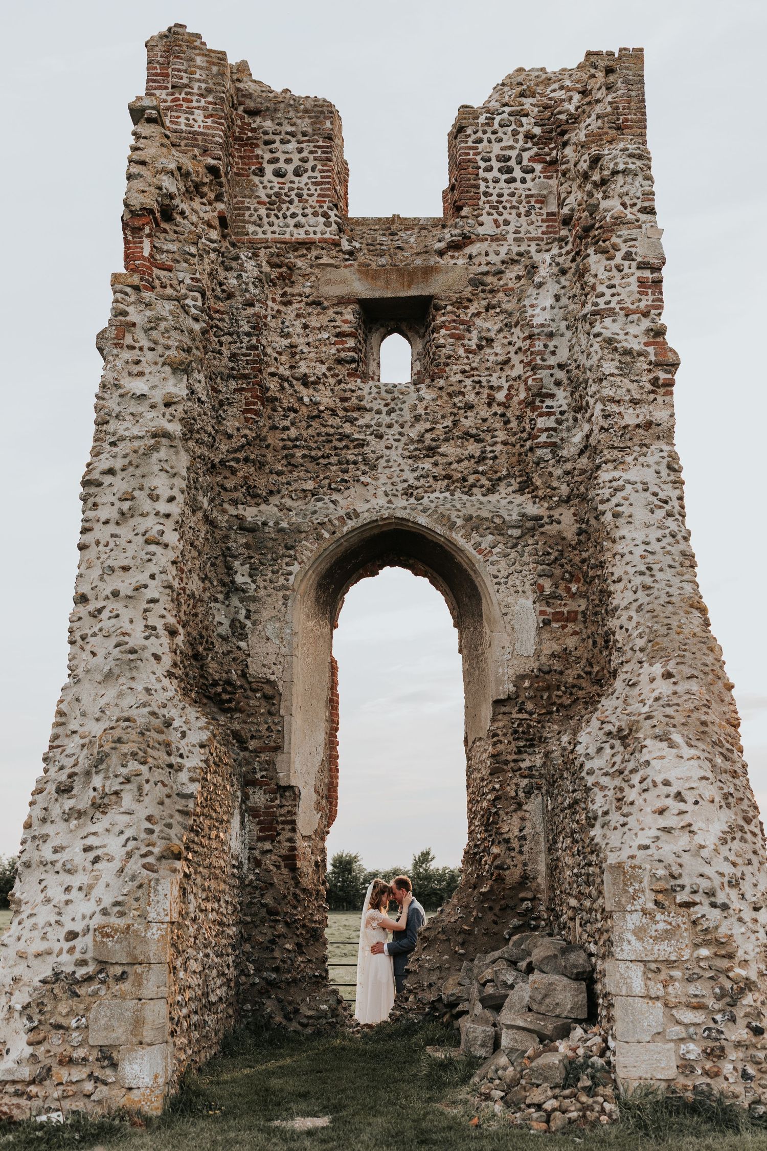 The image shows the ruins of an old stone castle or fortress, with a large arched entryway and crumbling walls.
