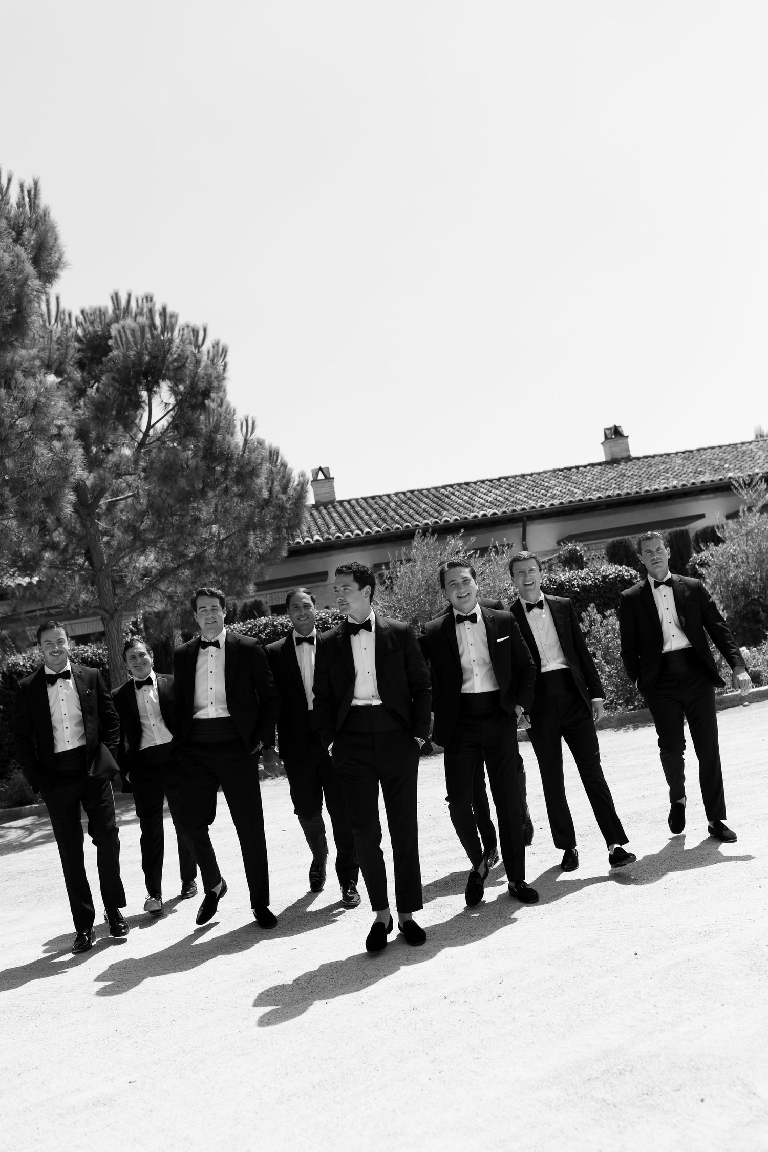 A group of men dressed in black suits standing together outdoors in front of a building.