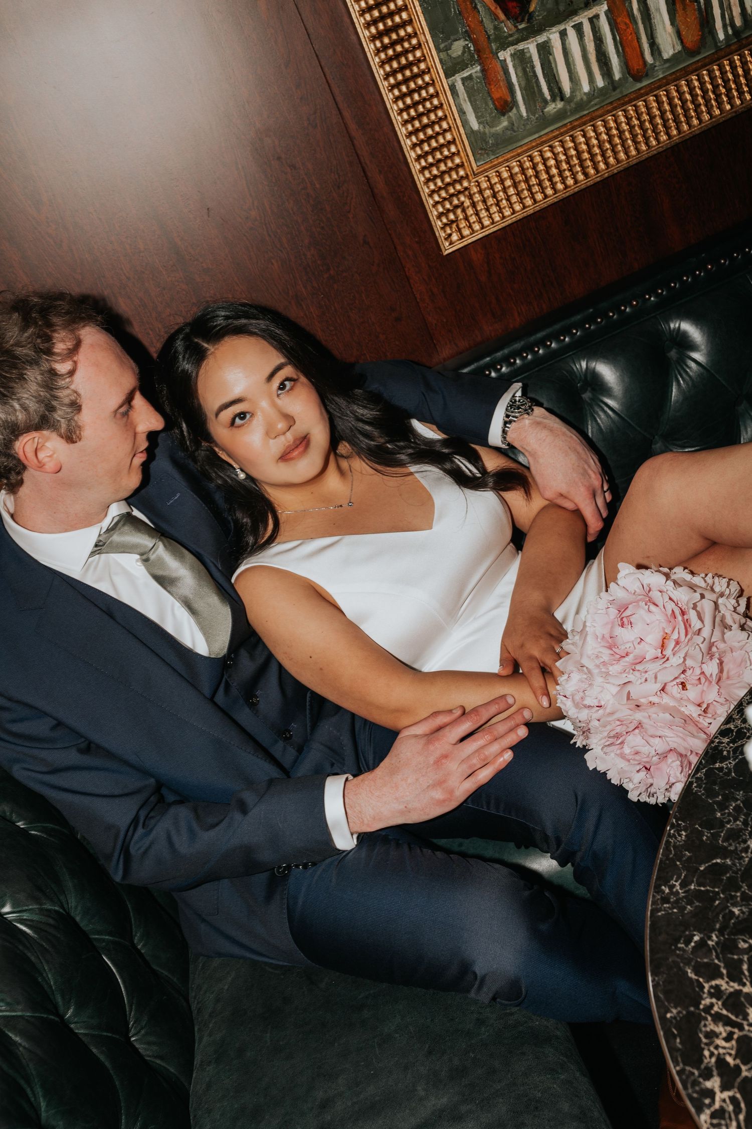 A couple sitting closely together on a couch, with the woman resting her head on the man's shoulder.