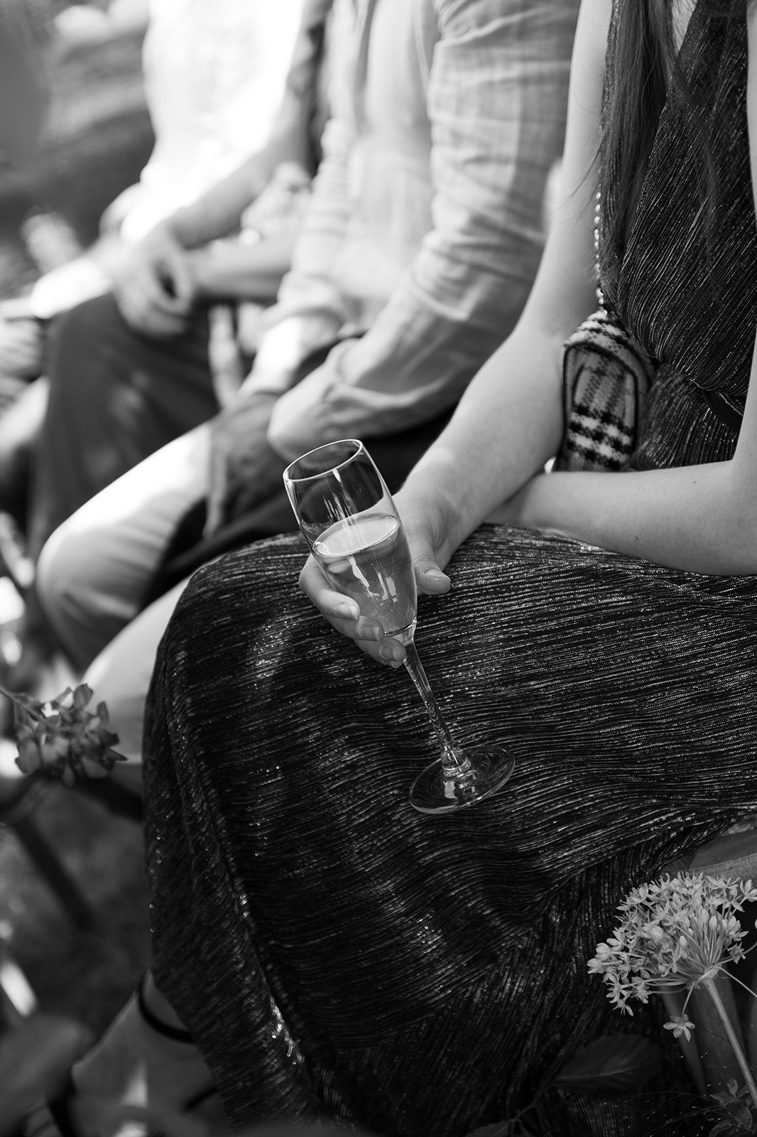 Black and white photo of a woman holding a champagne flute at a formal event.