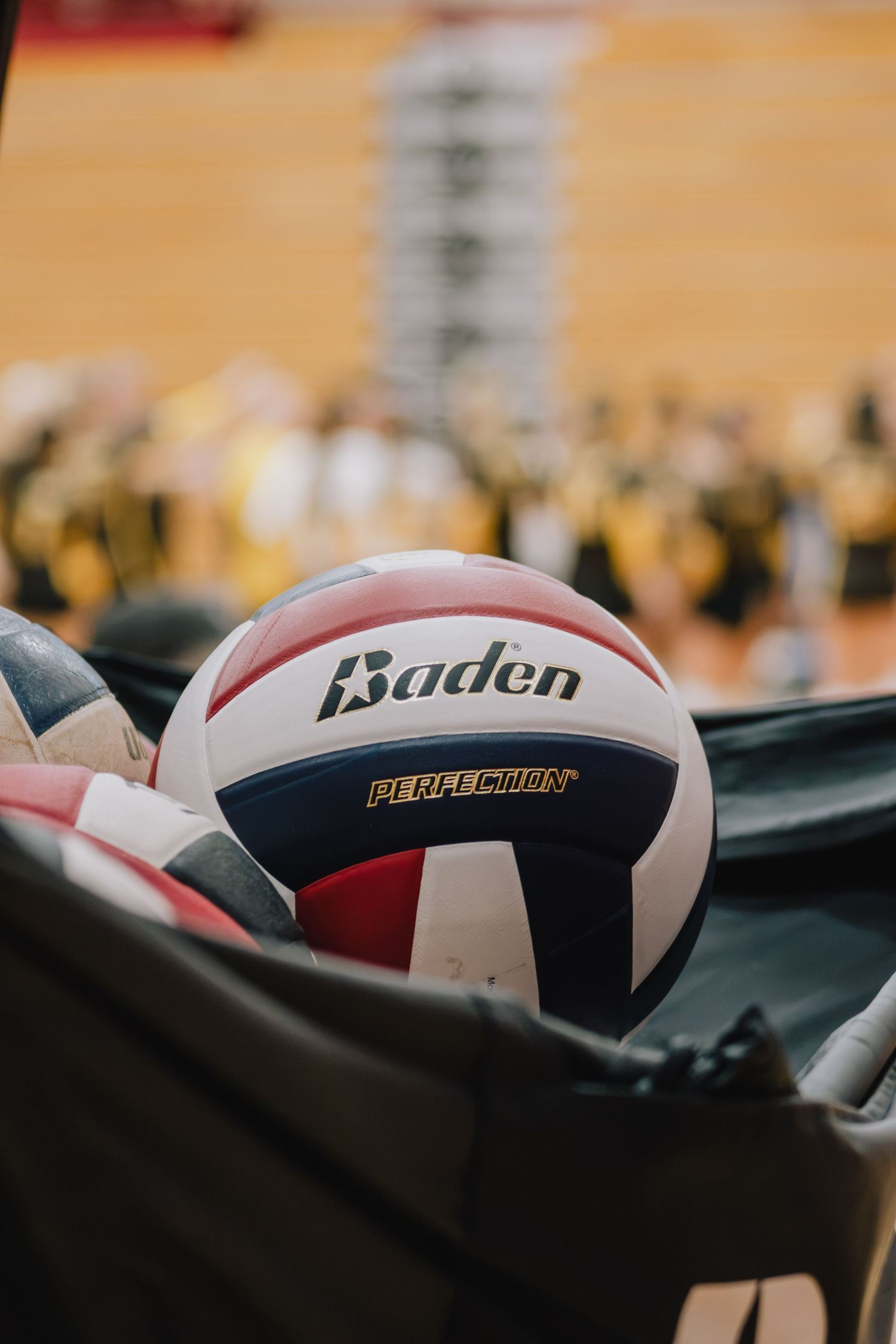 Close-up of an IUSB volleyball player holding a volleyball during an indoor match.