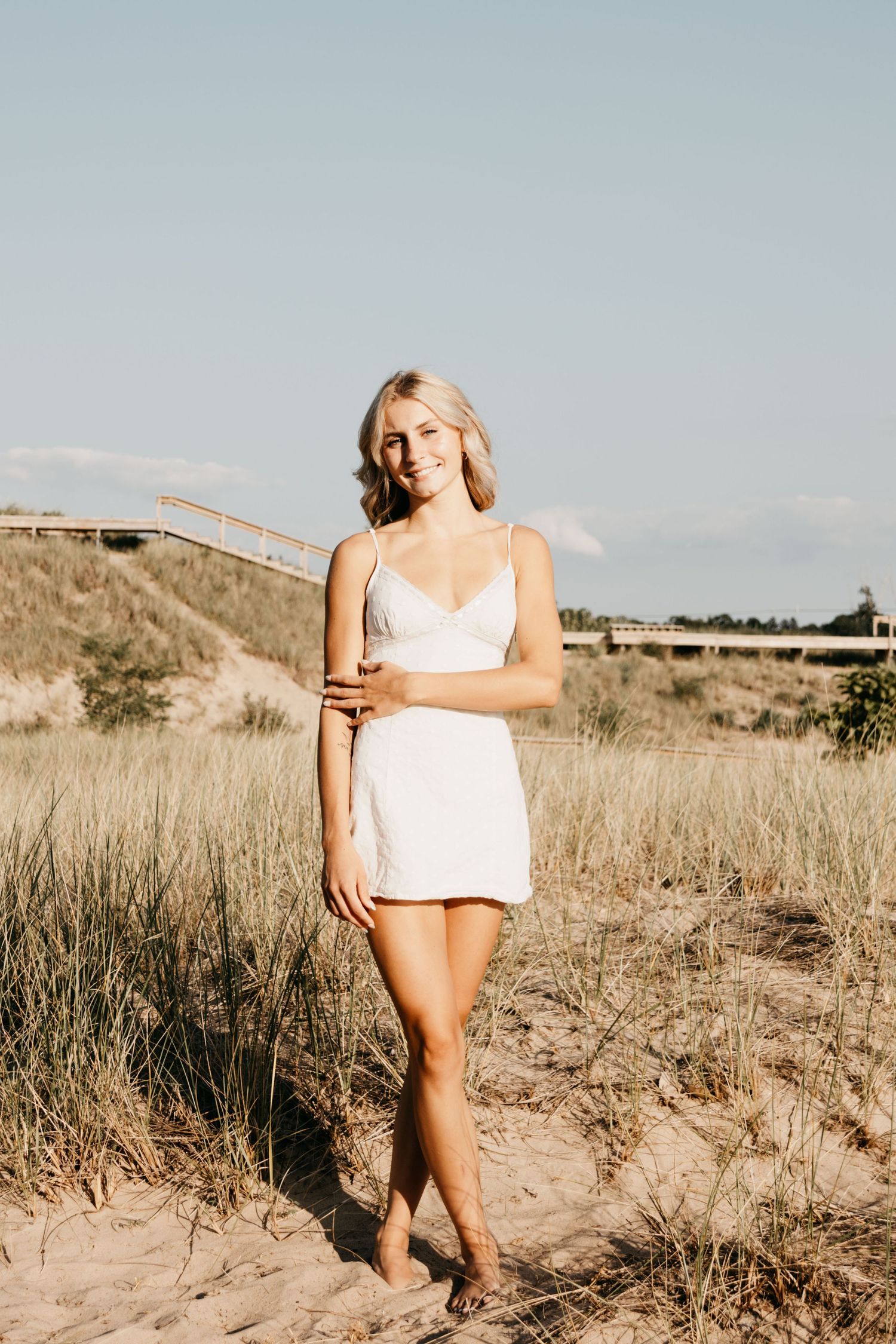 Senior portrait of Arabella Churchill standing by the water at sunset