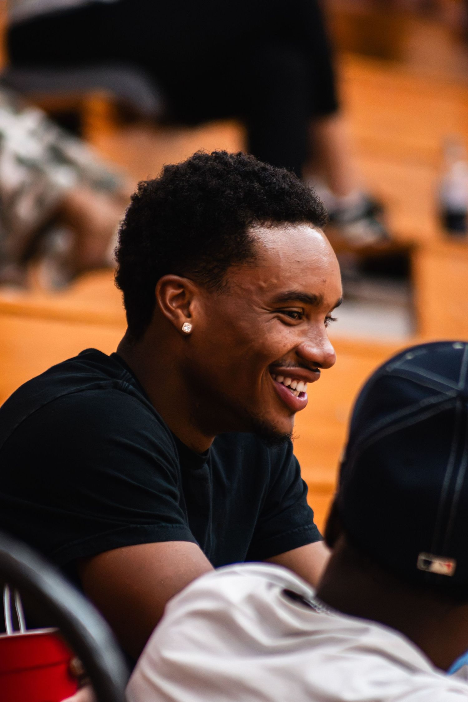 IUSB volleyball player smiling on the sideline during an indoor college volleyball match.
