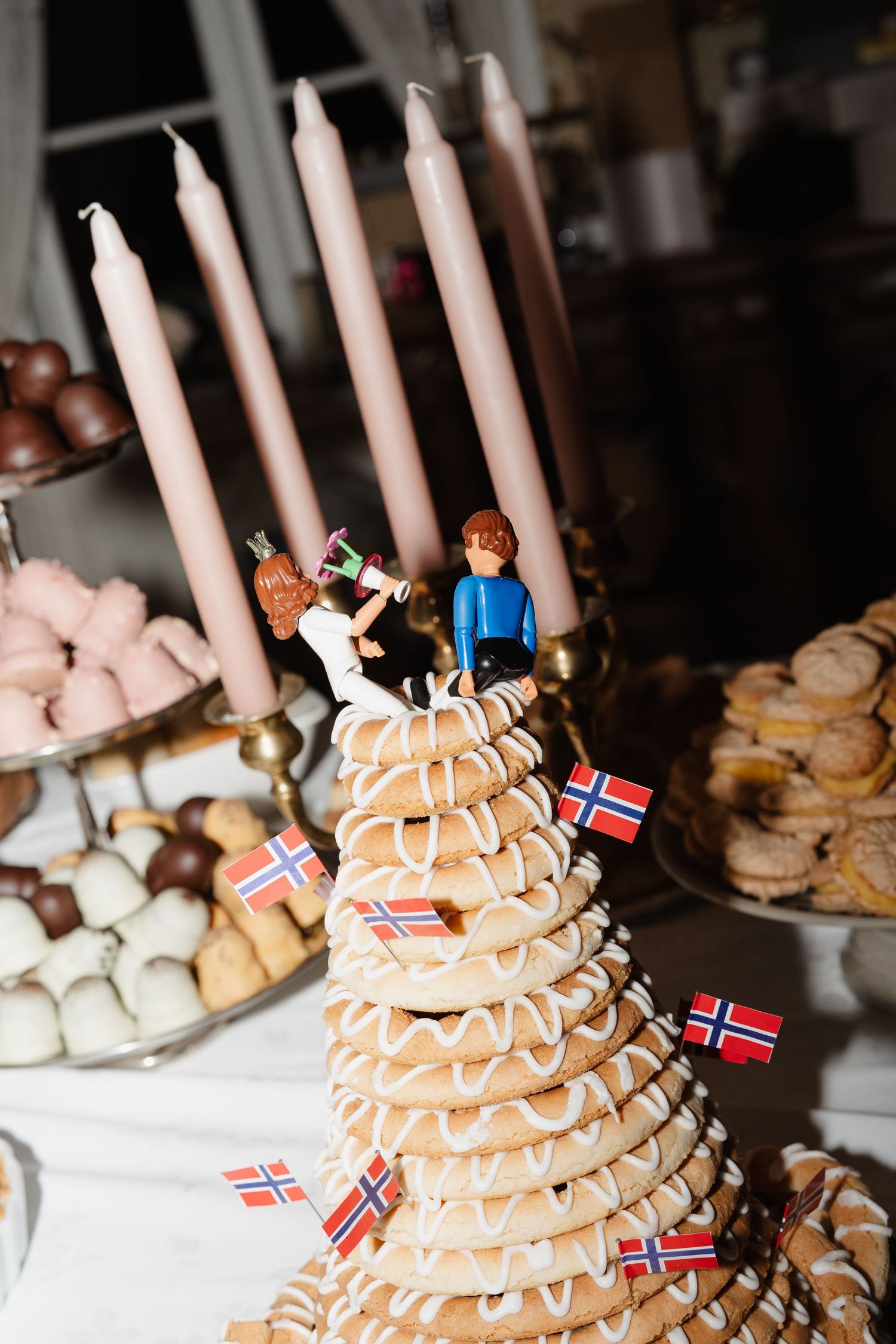 Traditional Norwegian kransekake wedding cake with Norwegian flags and LEGO couple toppers.