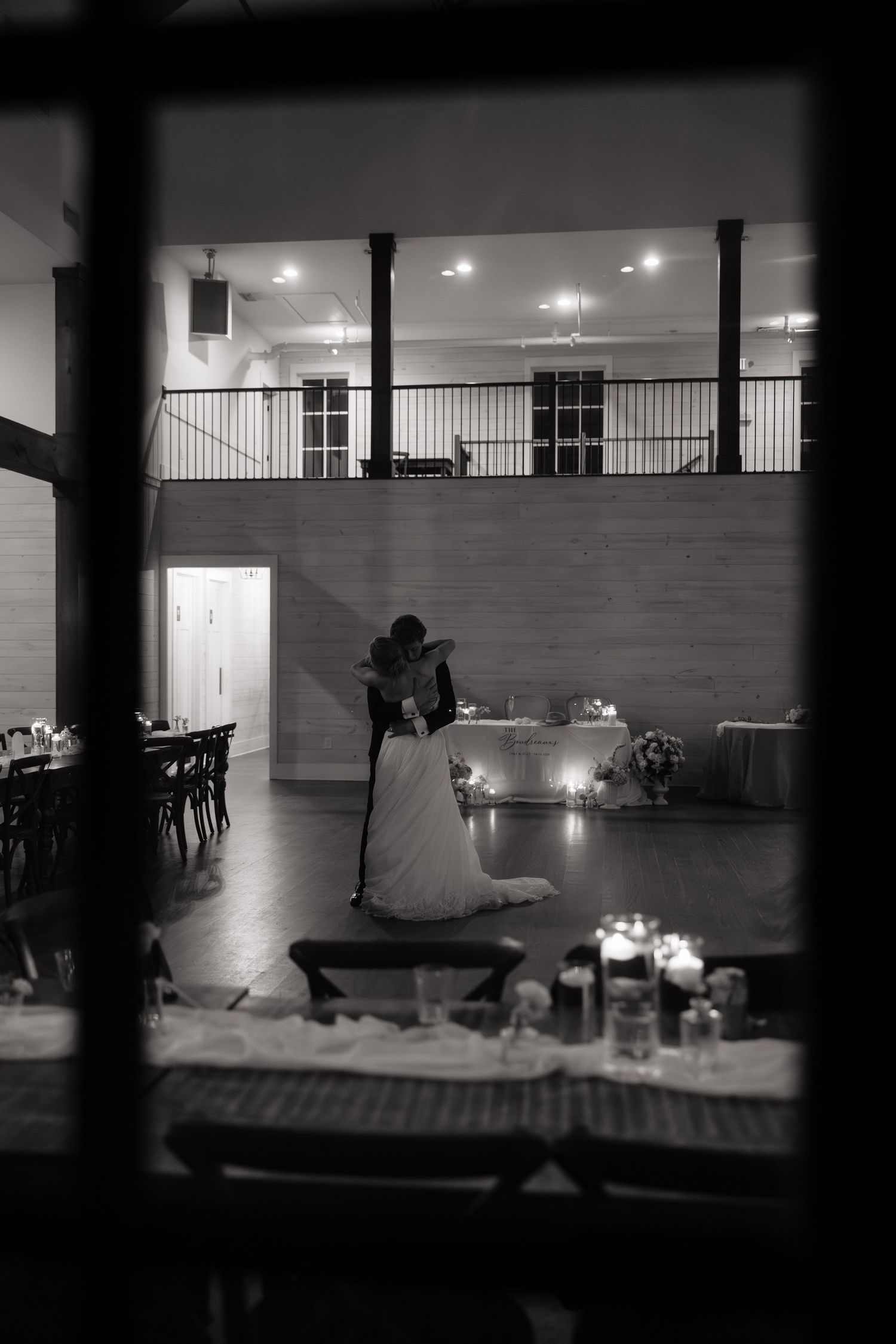 Black and white photo of bride and groom sharing first dance at elegant wedding reception.