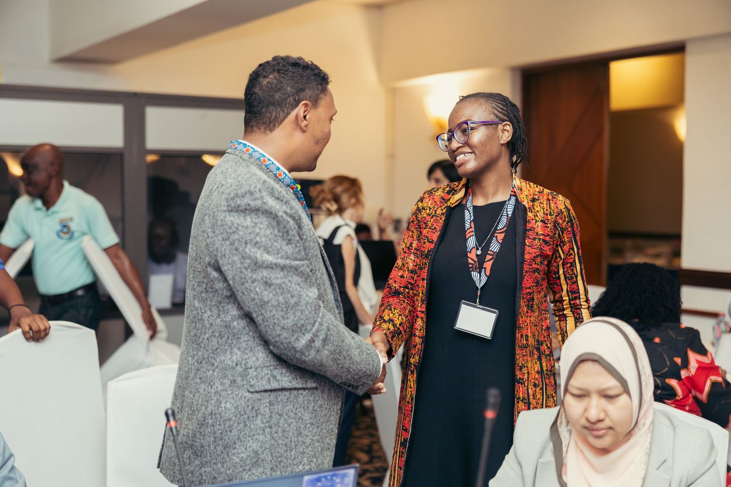 Two professionals engage in conversation at international conference networking event.