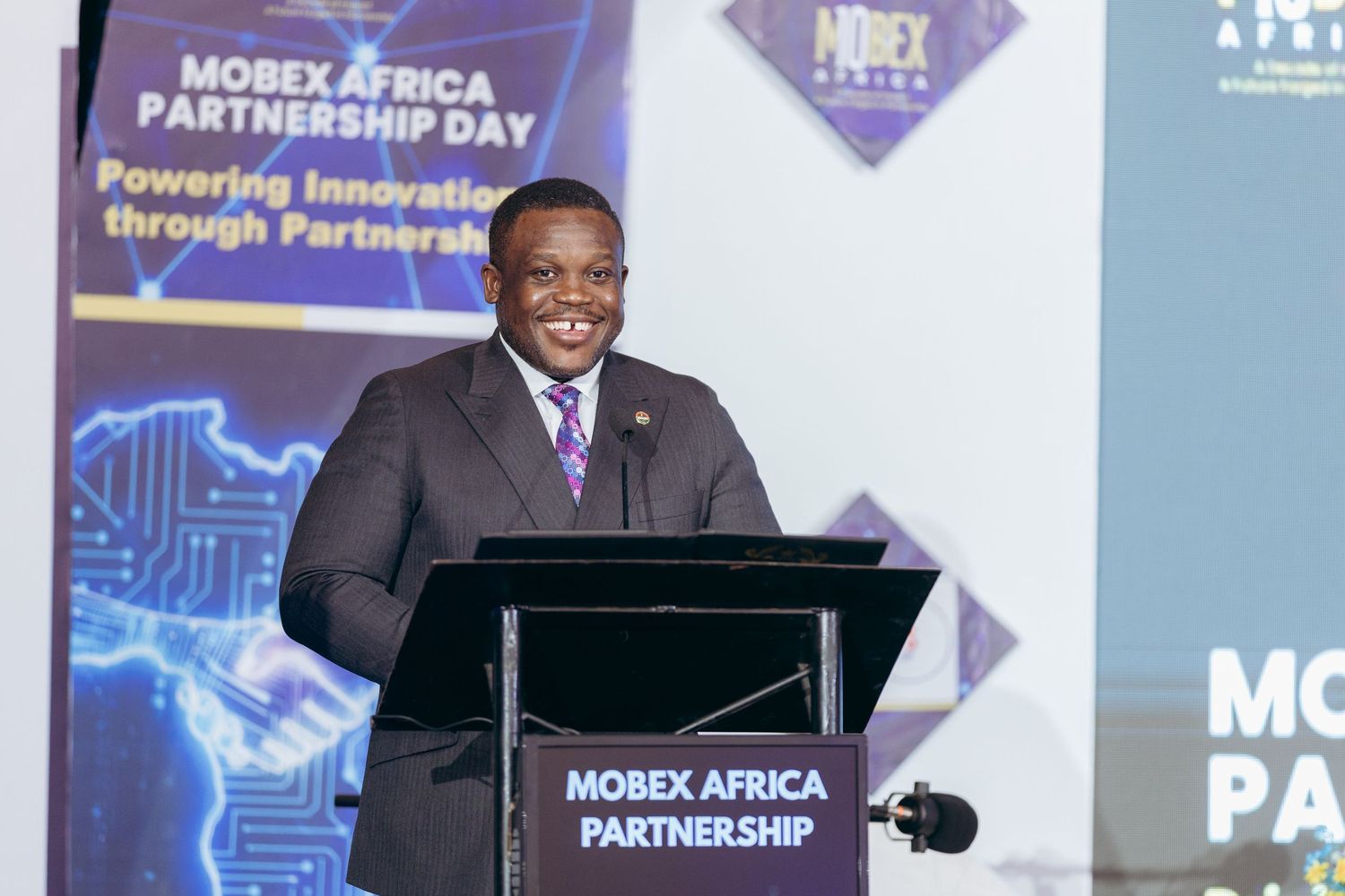 Speaker at podium presenting at Mobex Africa Partnership Day conference on powering innovation.