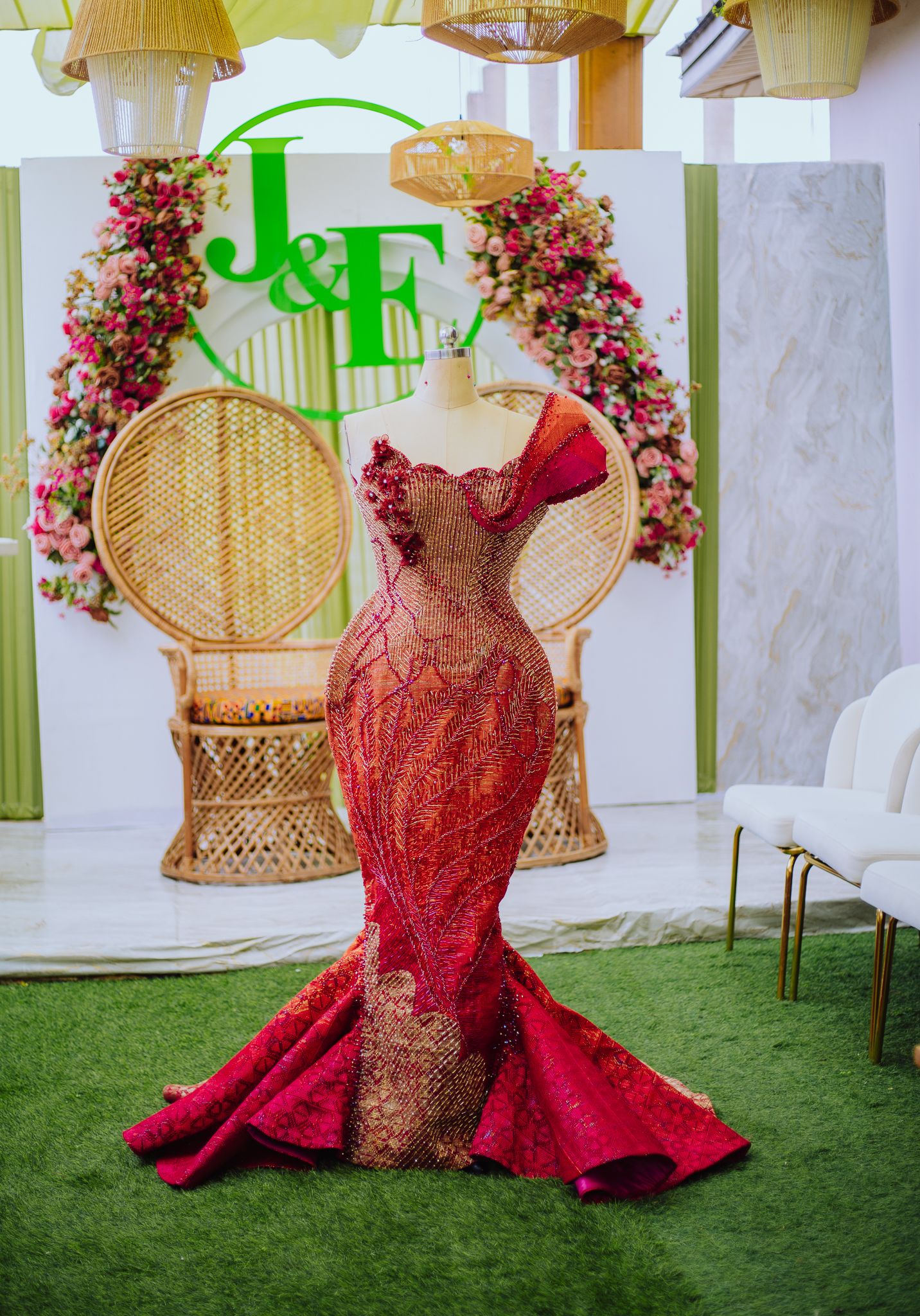 Stunning red and gold mermaid wedding gown displayed on mannequin at elegant J&F bridal showcase.