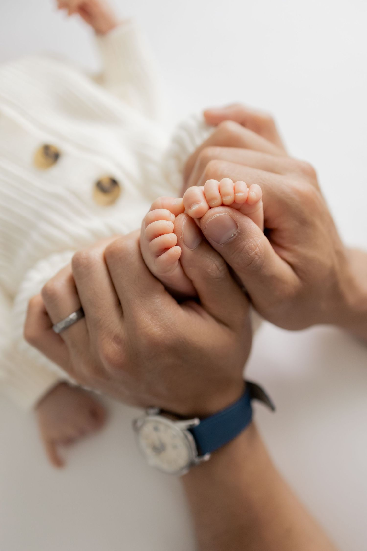 Father holding newborn baby's feet during a natural light lifestyle newborn session