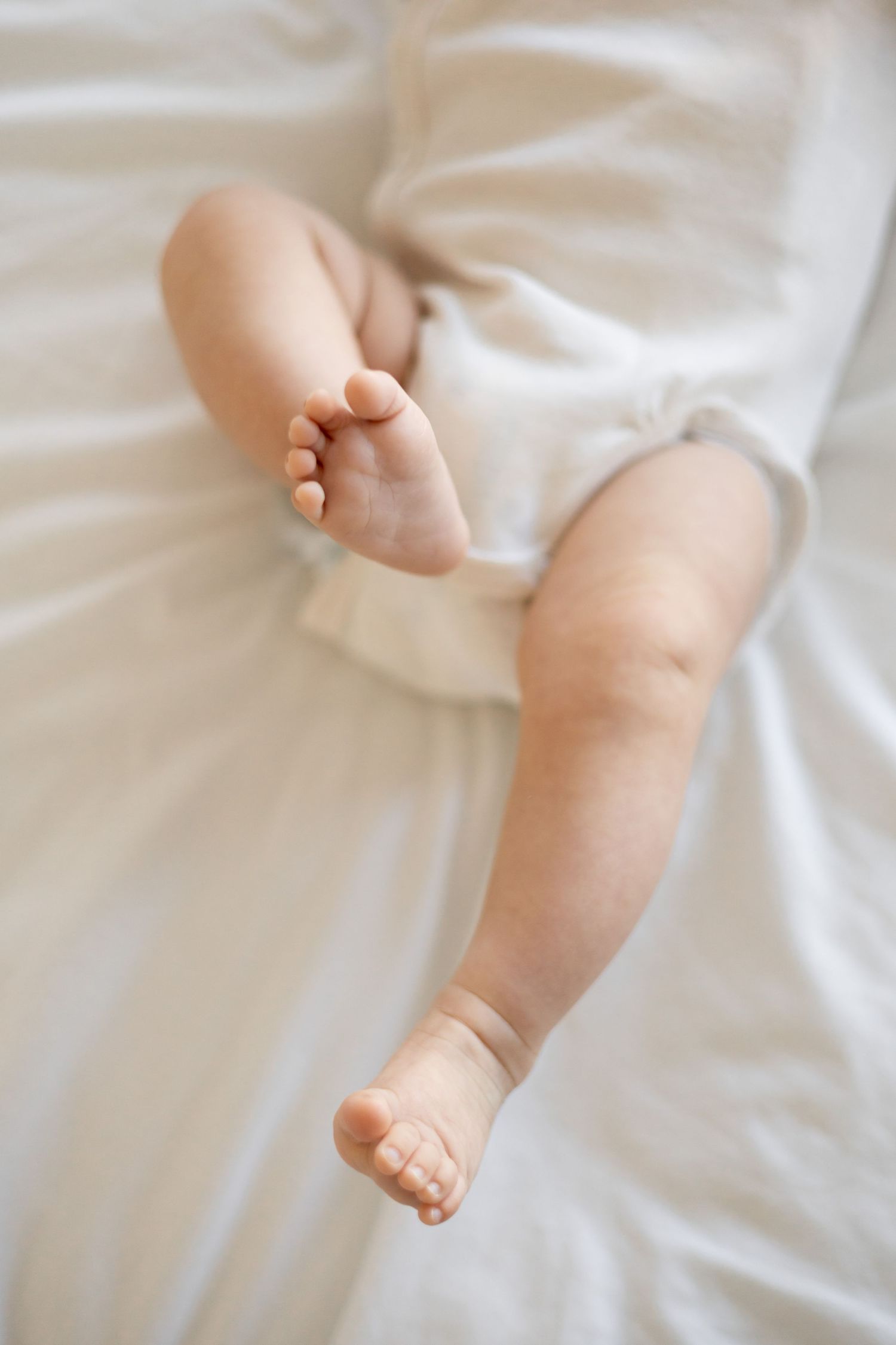 Baby playing with his feet during a natural light lifestyle newborn session