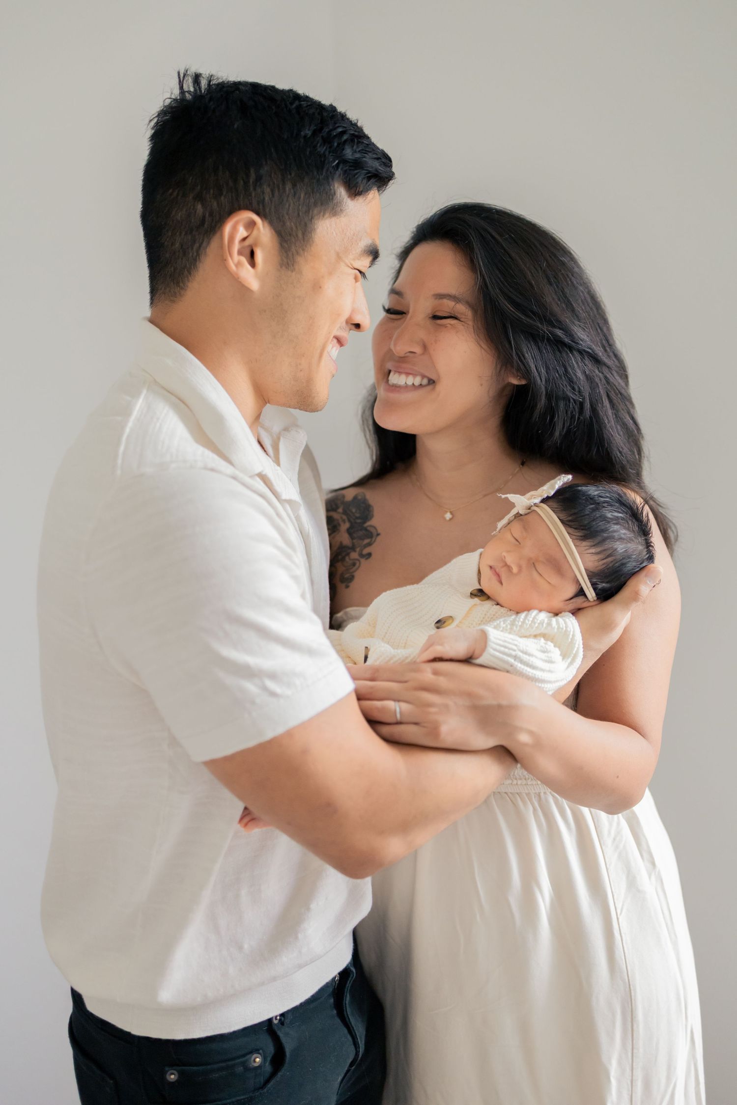 Parents cuddling newborn baby during a natural light lifestyle newborn session