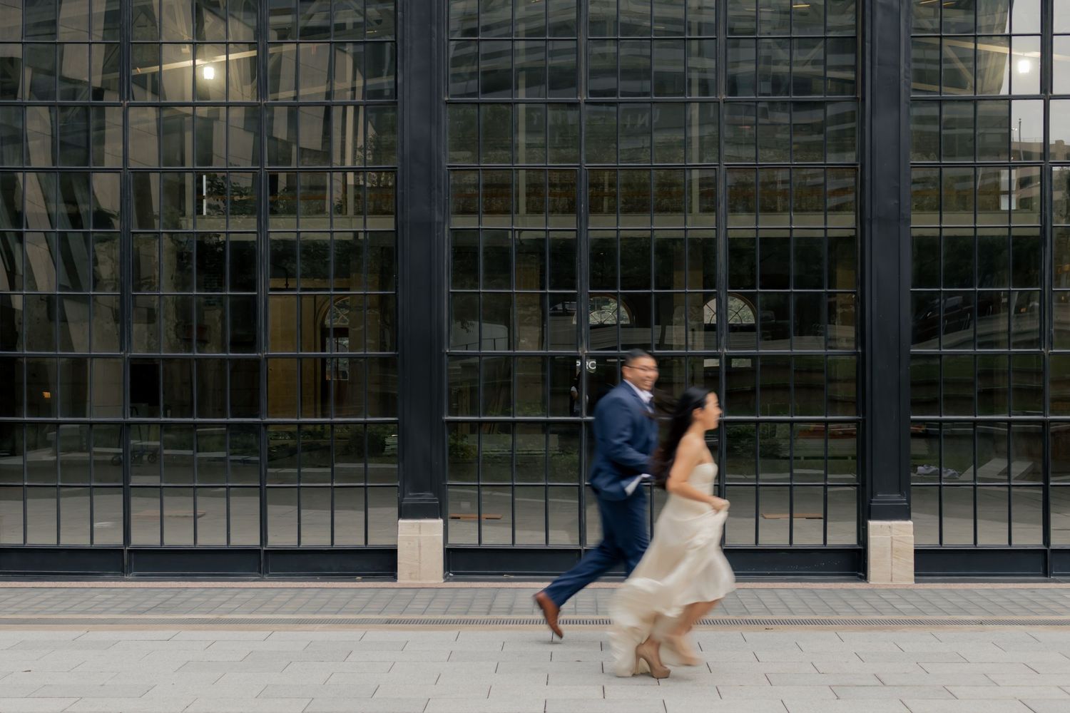 Couple holding hands and running together in downtown Austin during a sunrise engagement session