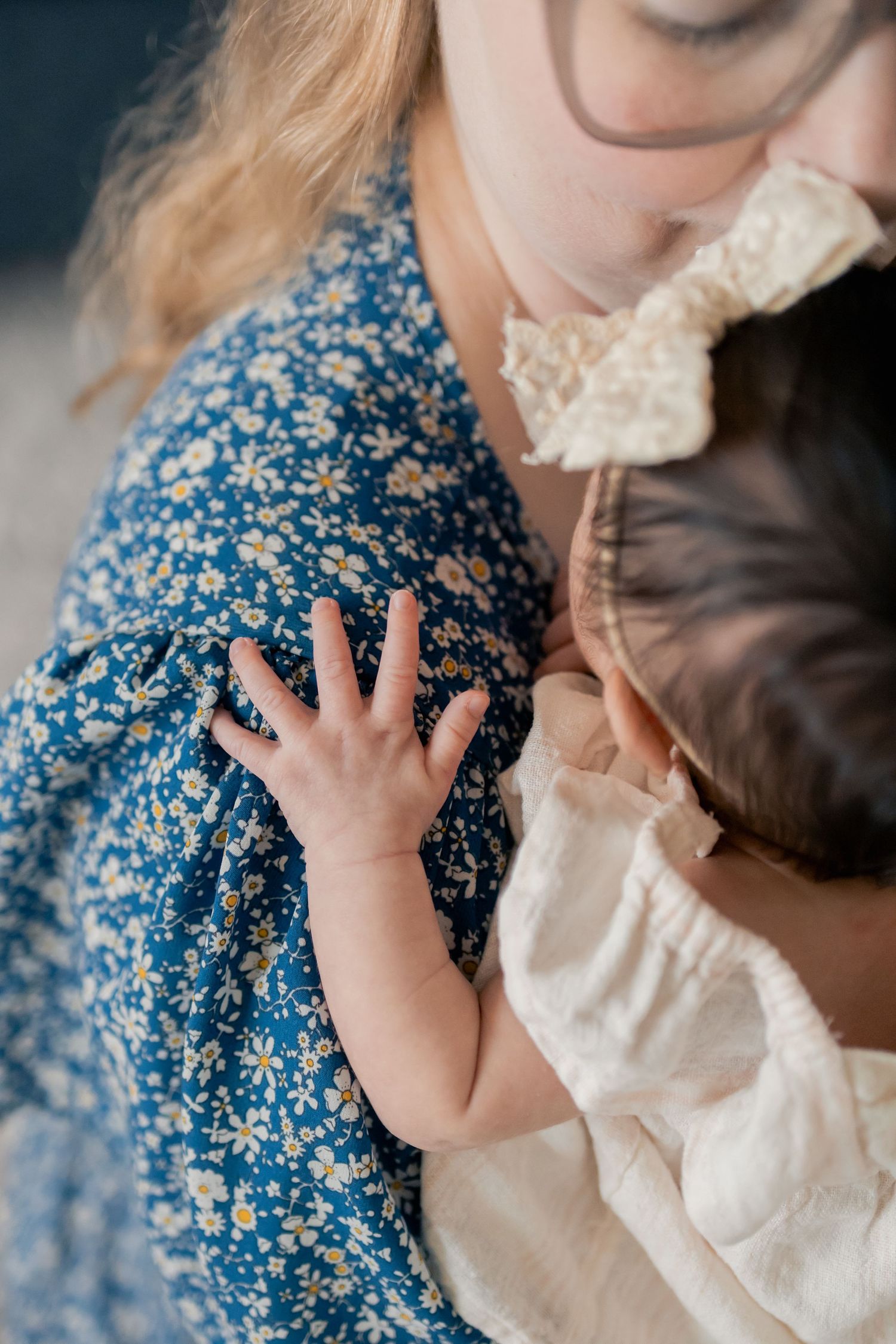 Mother cuddling newborn baby during a natural light lifestyle newborn session