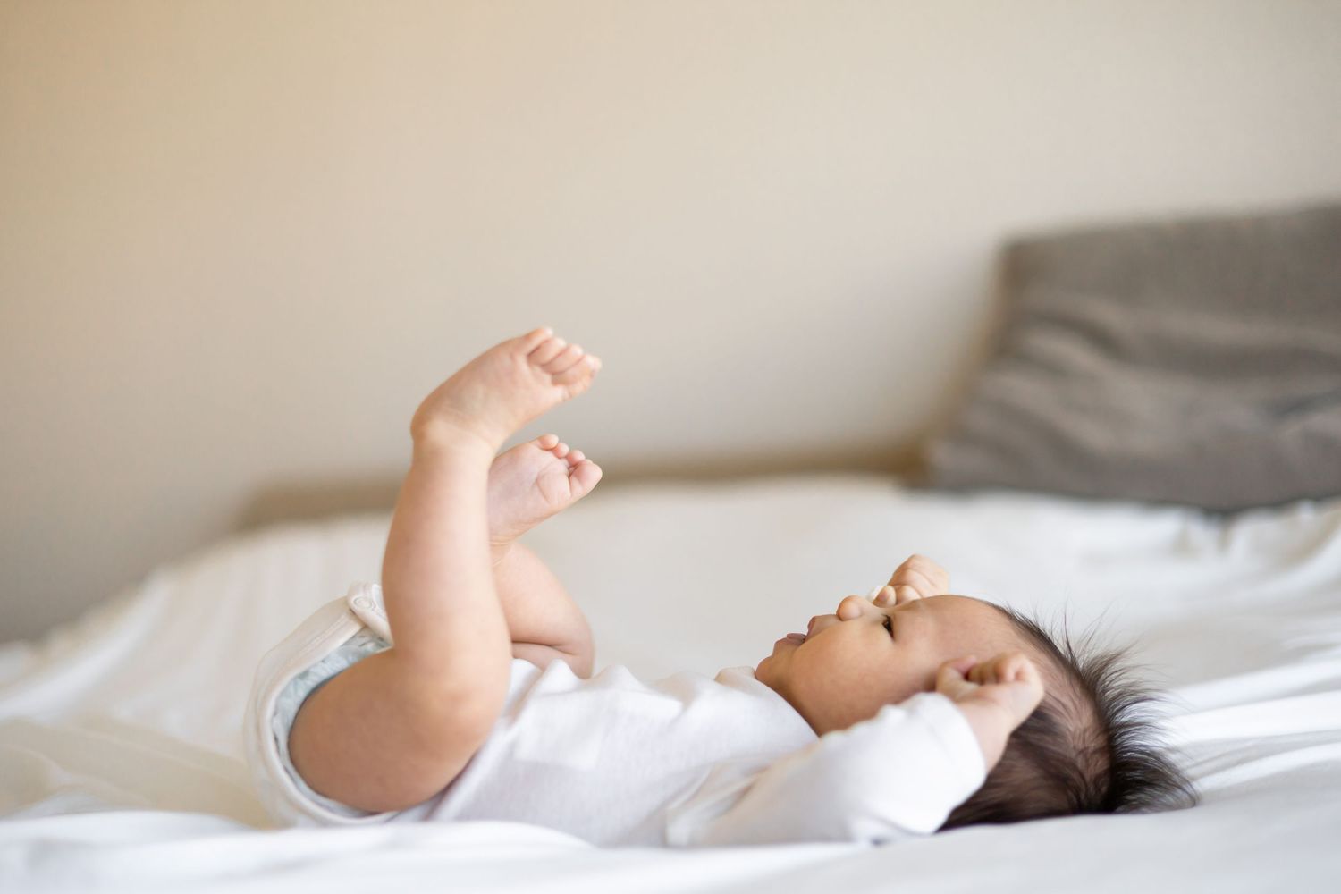 Baby playing with his feet during a natural light lifestyle newborn session