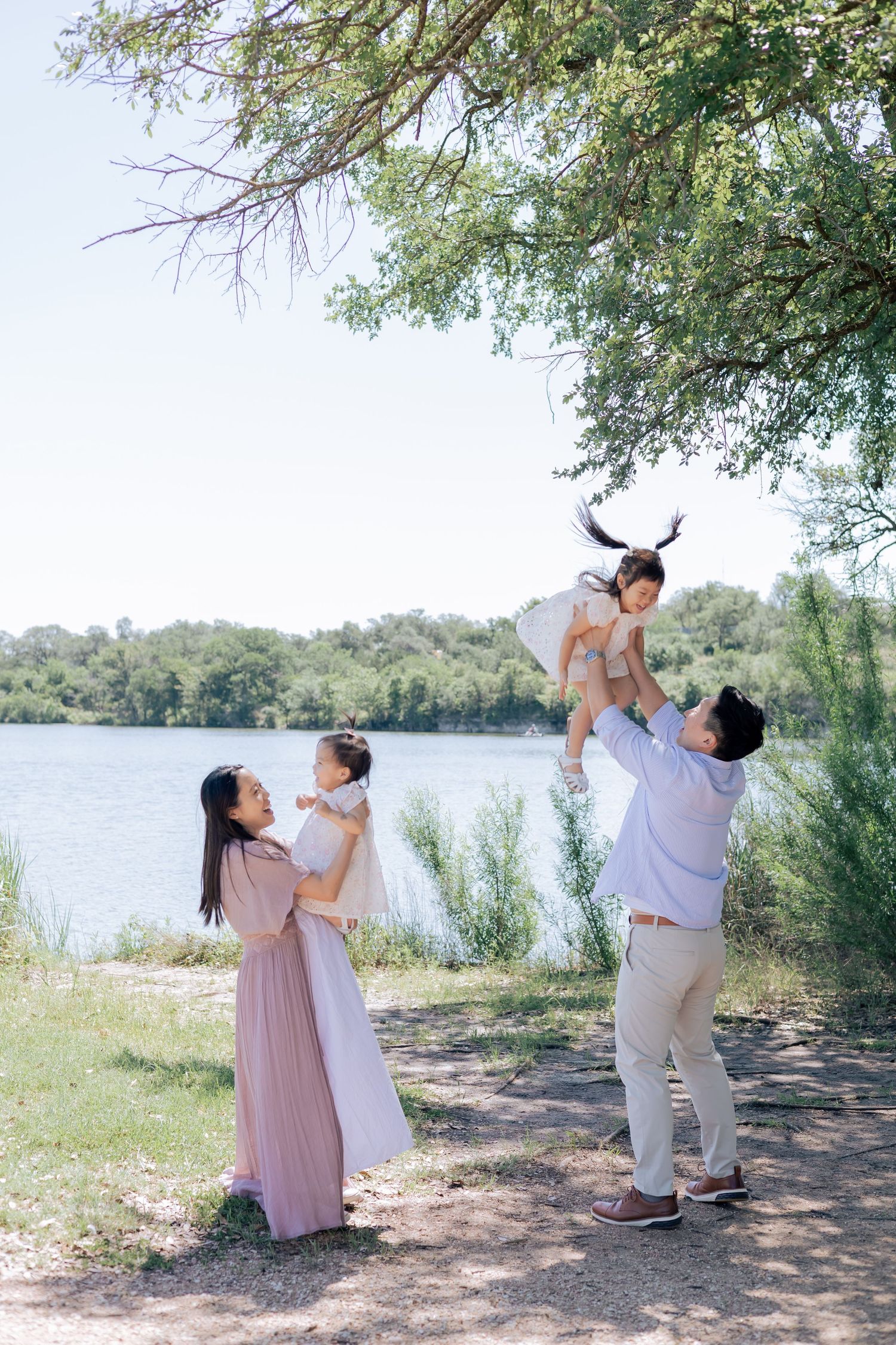 Parents playing with their children outside near a lake during a lifestyle family maternity session