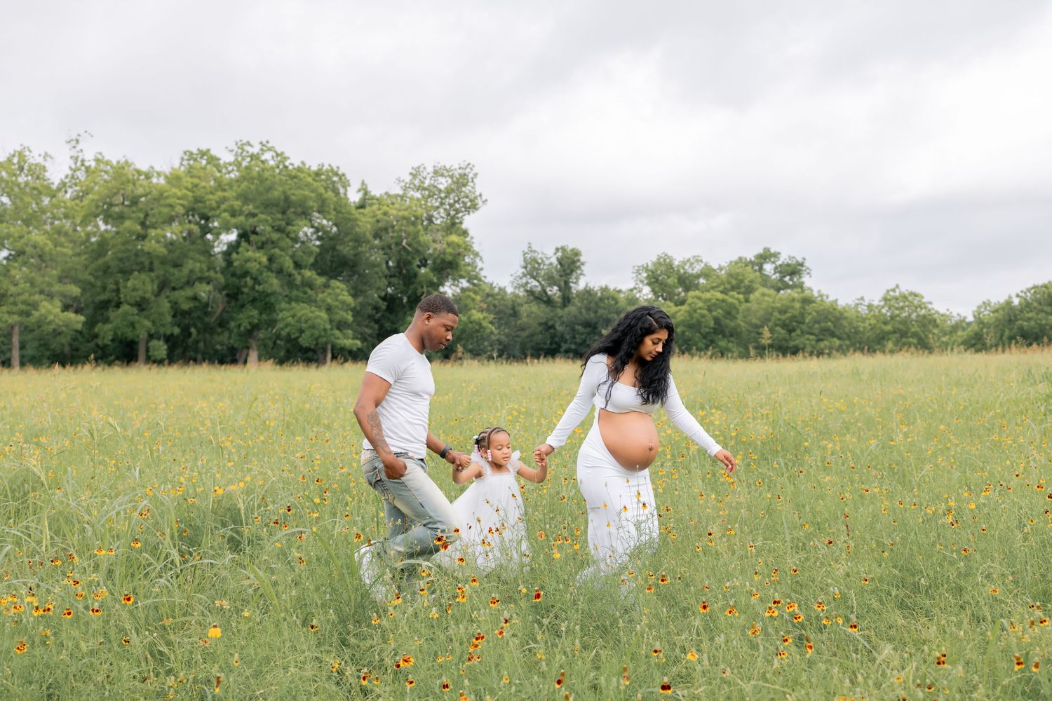Family walking together in a grassy field during a lifestyle family session