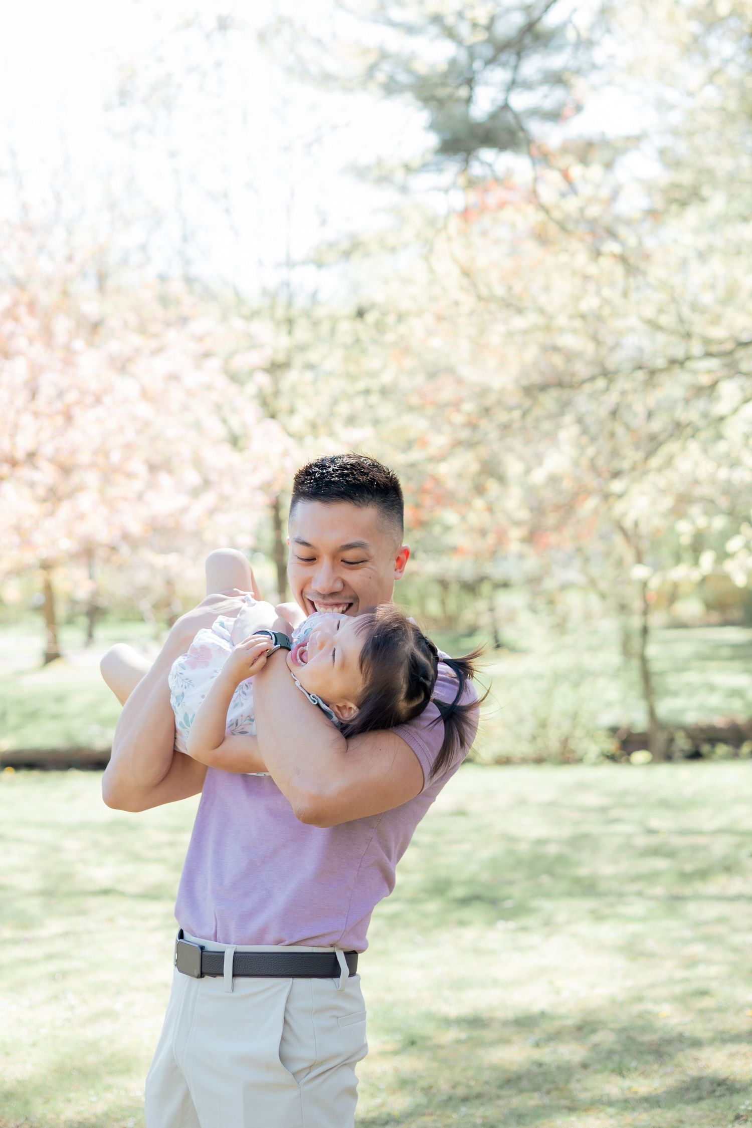 Father playing with daughter during a family lifestyle session in the park