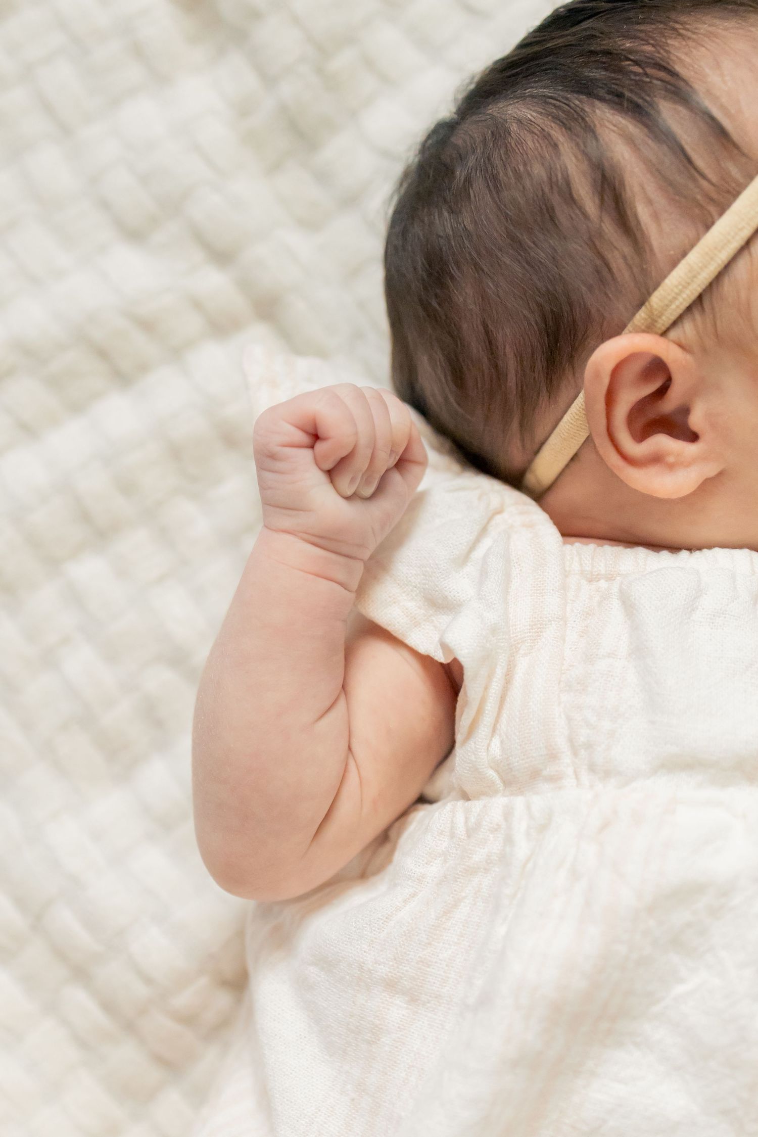 Closeup of newborn baby's hand and ear during a natural light lifestyle newborn session