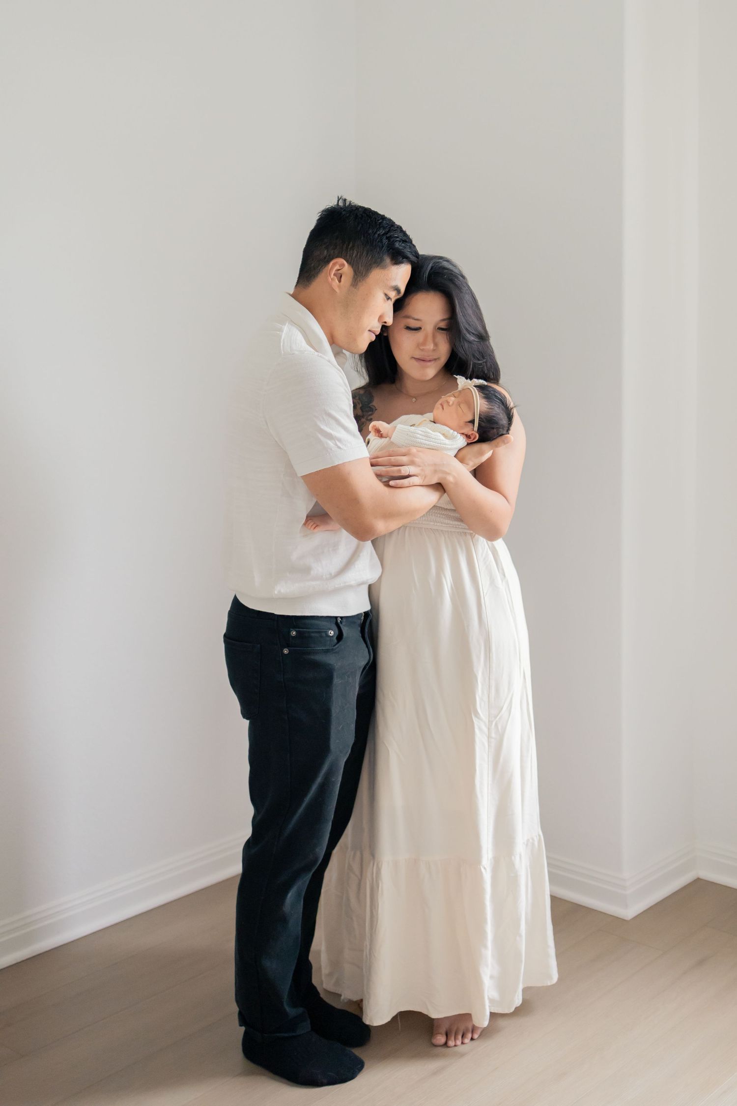 Parents cuddling newborn baby during a natural light lifestyle newborn session