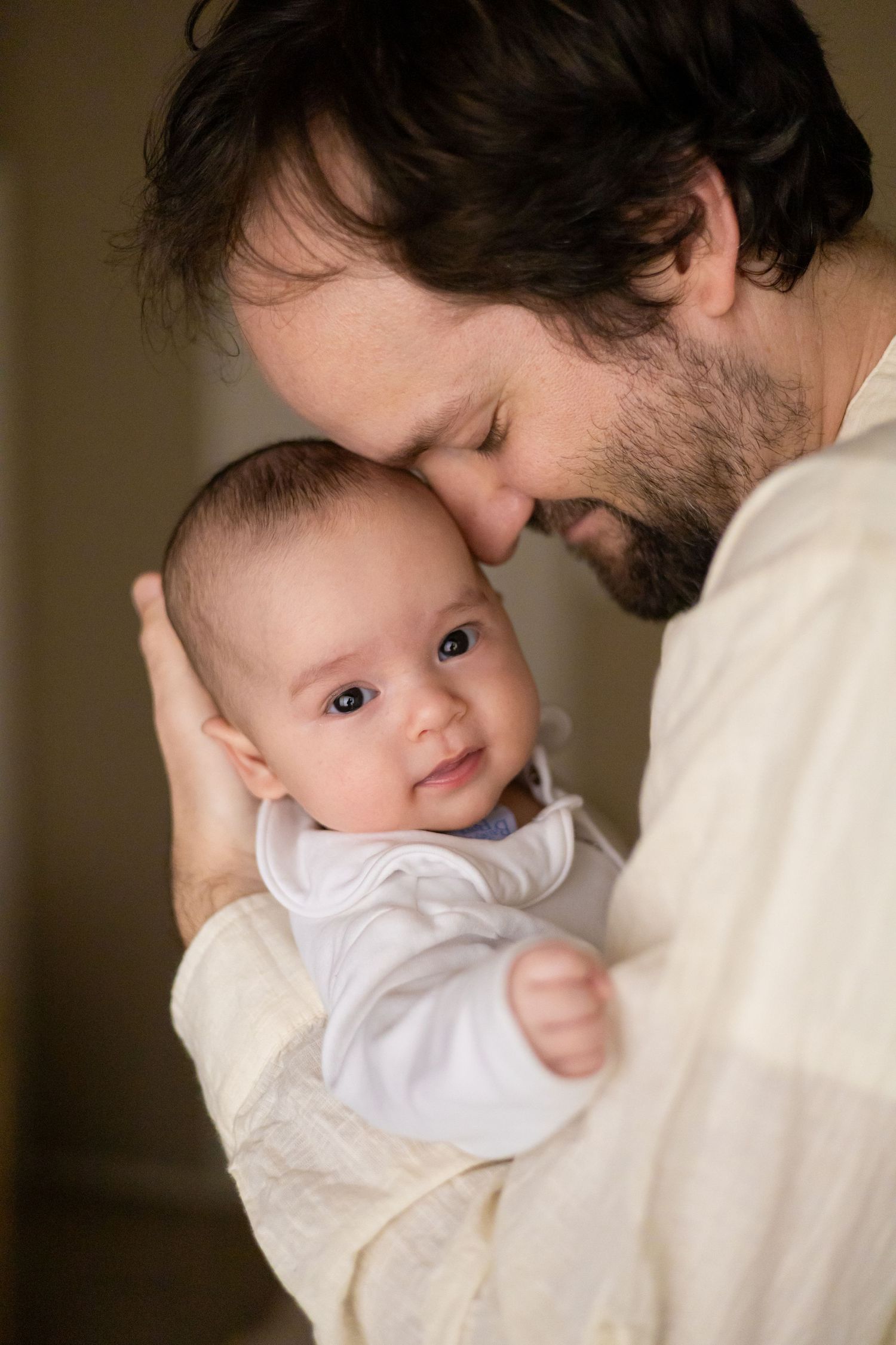 Father cuddling his newborn baby twins during a lifestyle newborn session