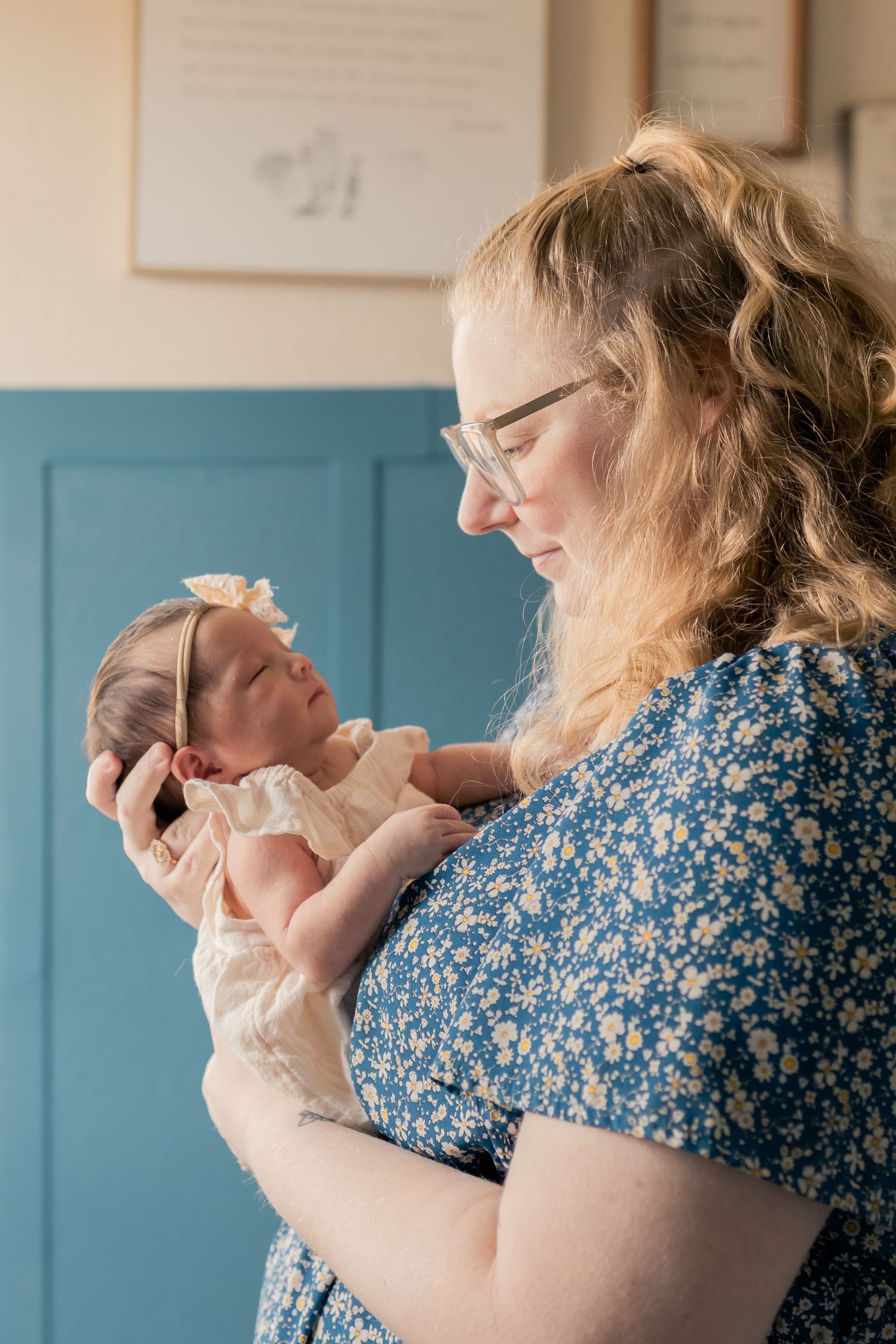 Mother cuddling newborn baby during a natural light lifestyle newborn session